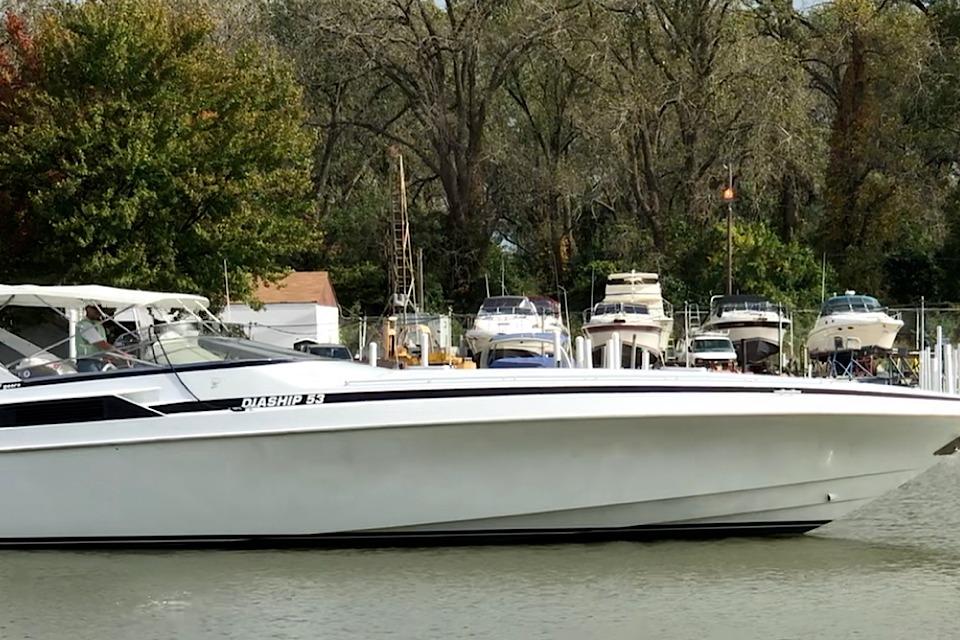 1999 Diaship 53 boat docked near marina with trees in background.