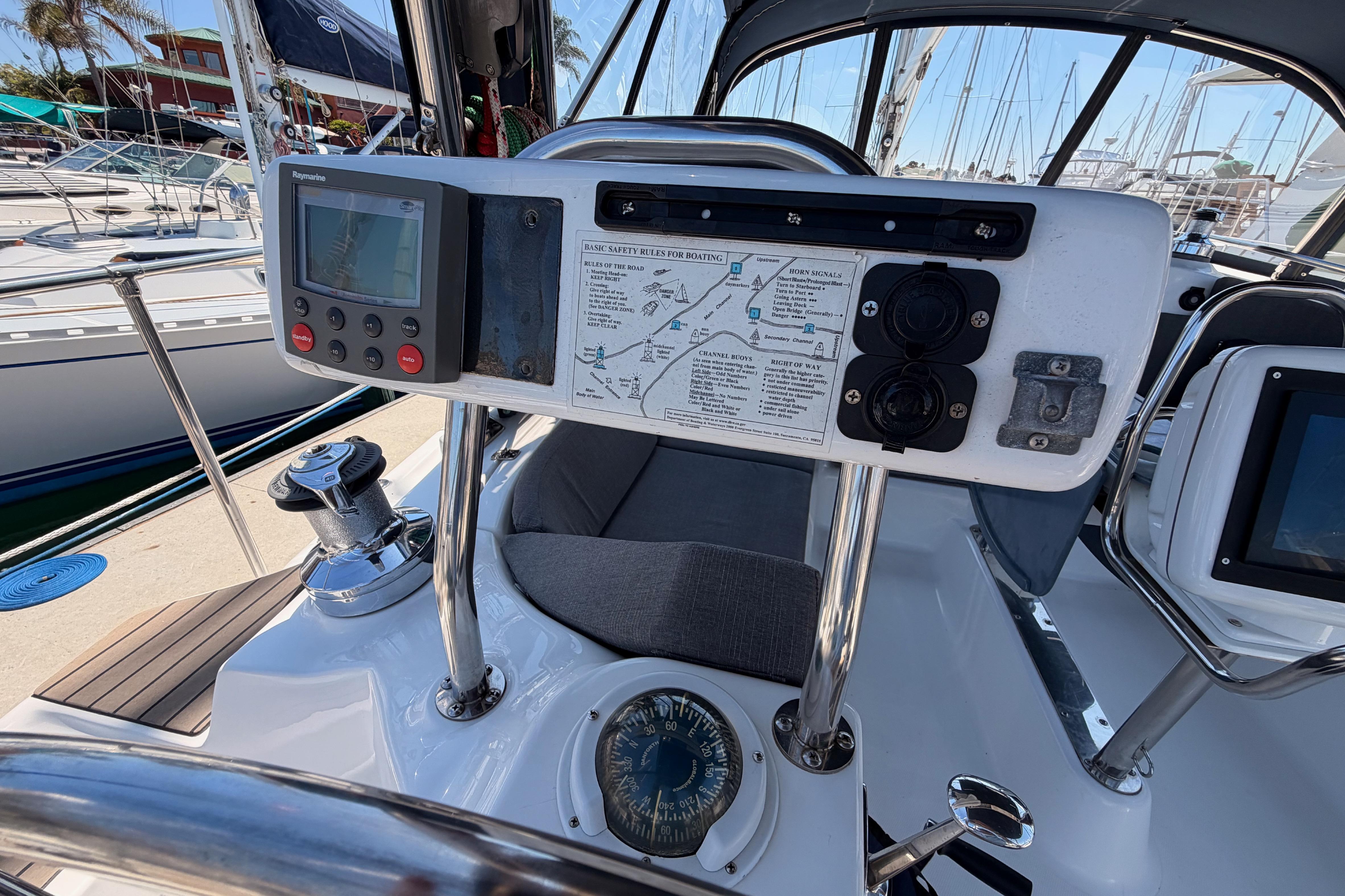 Cockpit of 2008 Hunter 45 Deck Salon sailboat with navigation equipment and safety instructions.