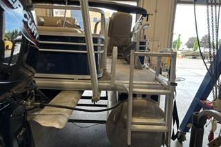 2022 Sun Tracker Fishin' Barge 22 DLX pontoon boat in a garage setting.