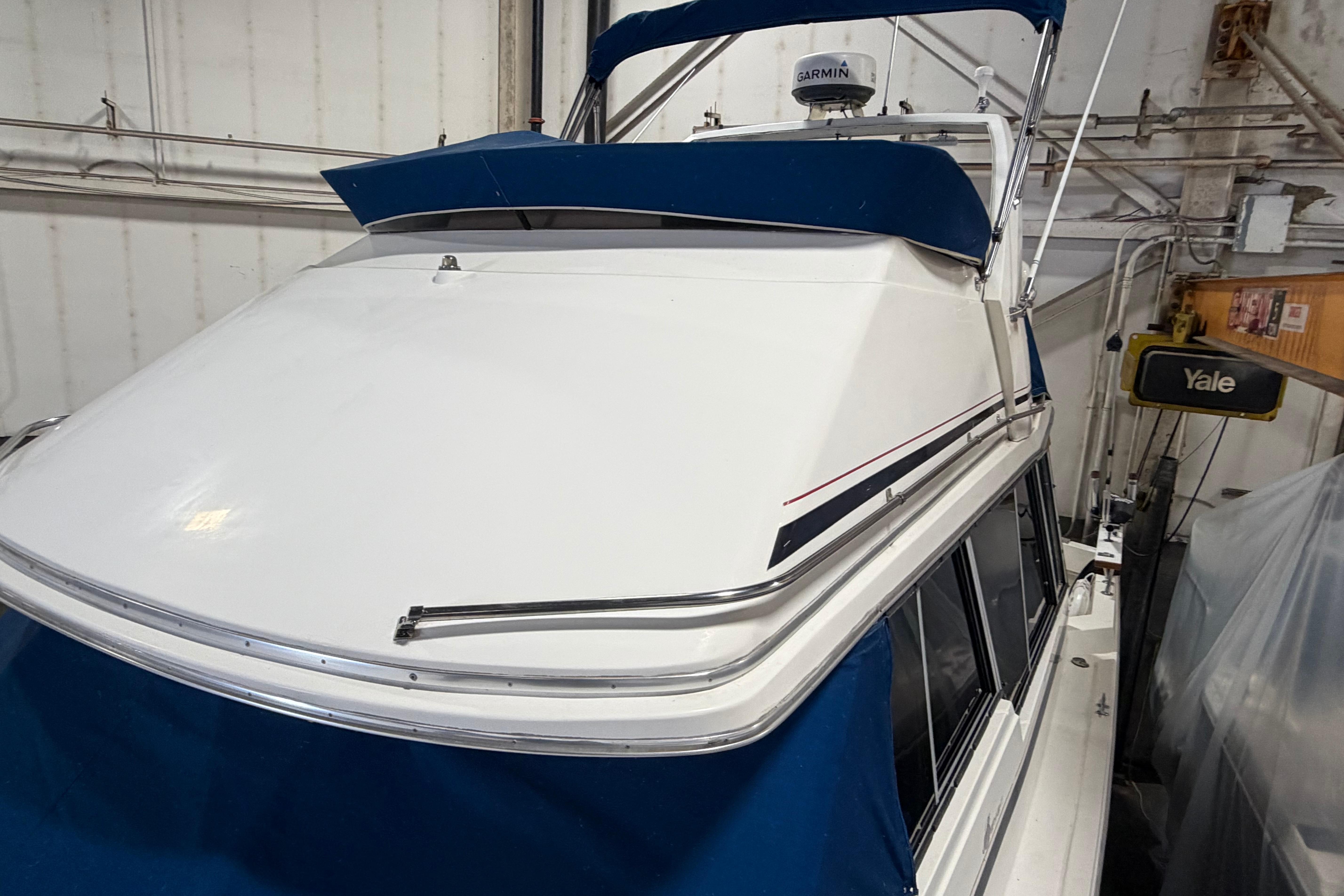 1986 Bayliner 3270 Motoryacht in storage, featuring blue and white exterior.