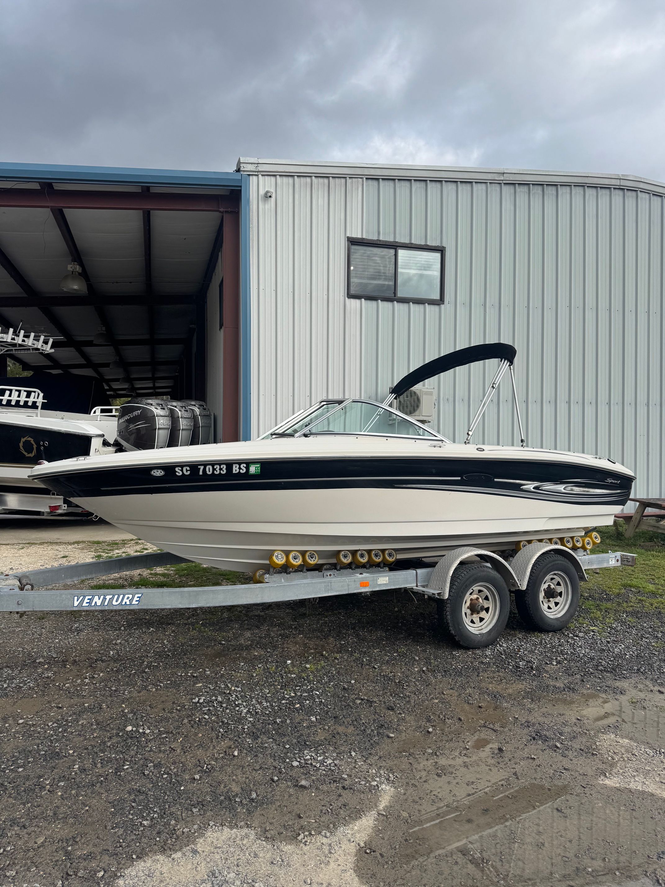 A 2005 Sea Ray 185 Sport on a trailer in front of a building.