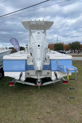 2026 Robalo 246 Cayman boat, rear view, displayed outdoors on grass.
