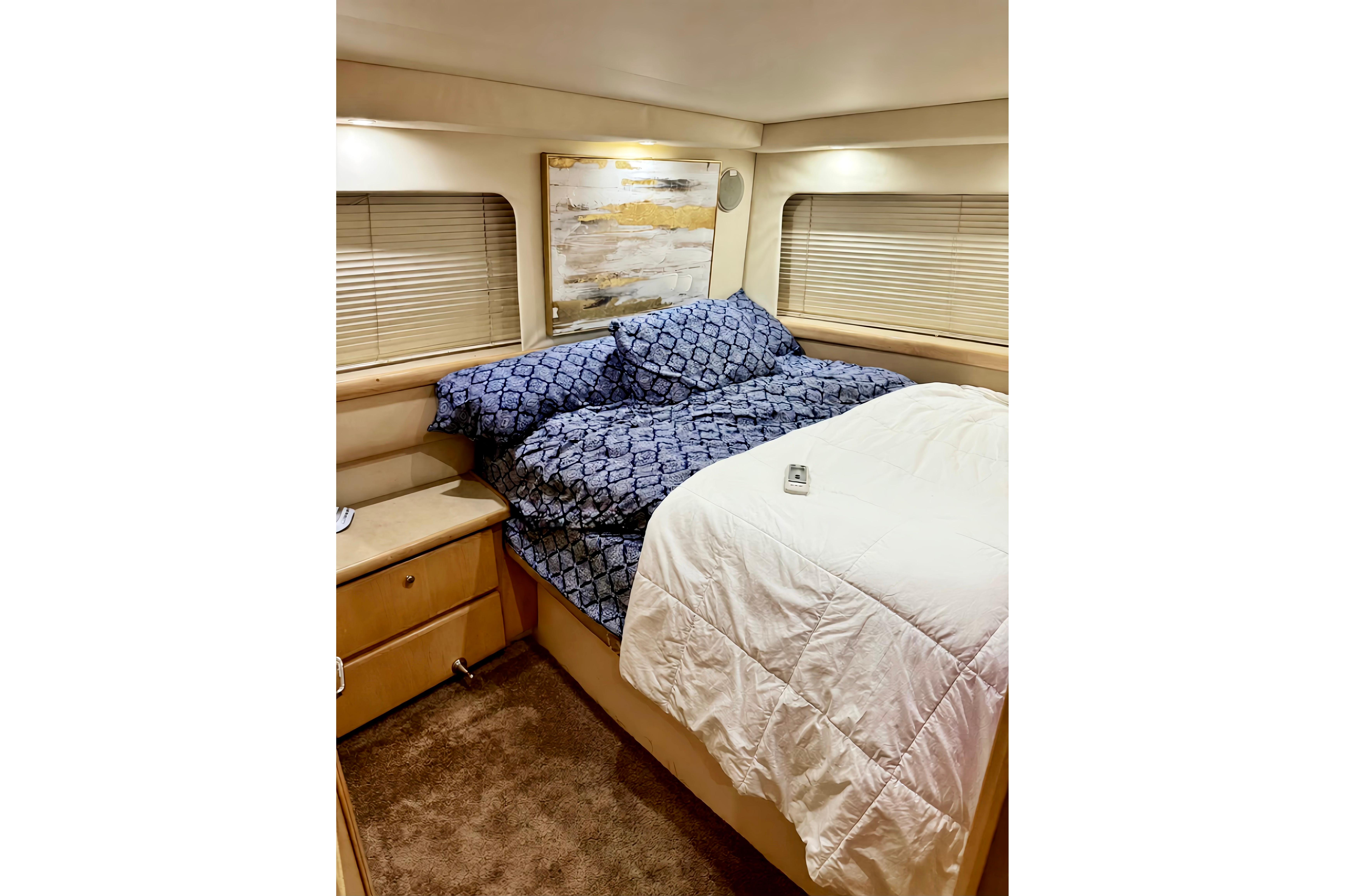 Cozy bedroom in 1998 Carver 355 Aft Cabin Motor Yacht with blue bedding.