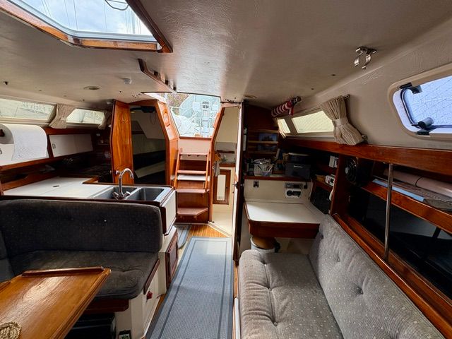 Interior of a 1989 Catalina 34 with cozy seating areas and wooden accents.