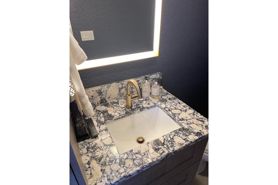 Luxurious bathroom sink with marble countertop and gold faucet, Adonia The Queen Elizabeth 2021.
