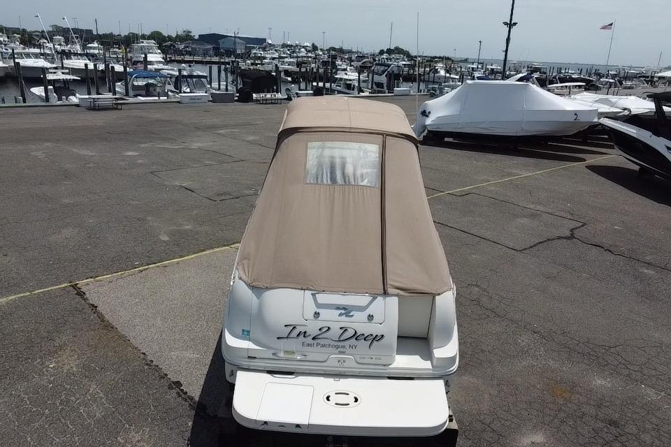 2001 Sea Ray 245 Weekender boat covered at marina, rear view.