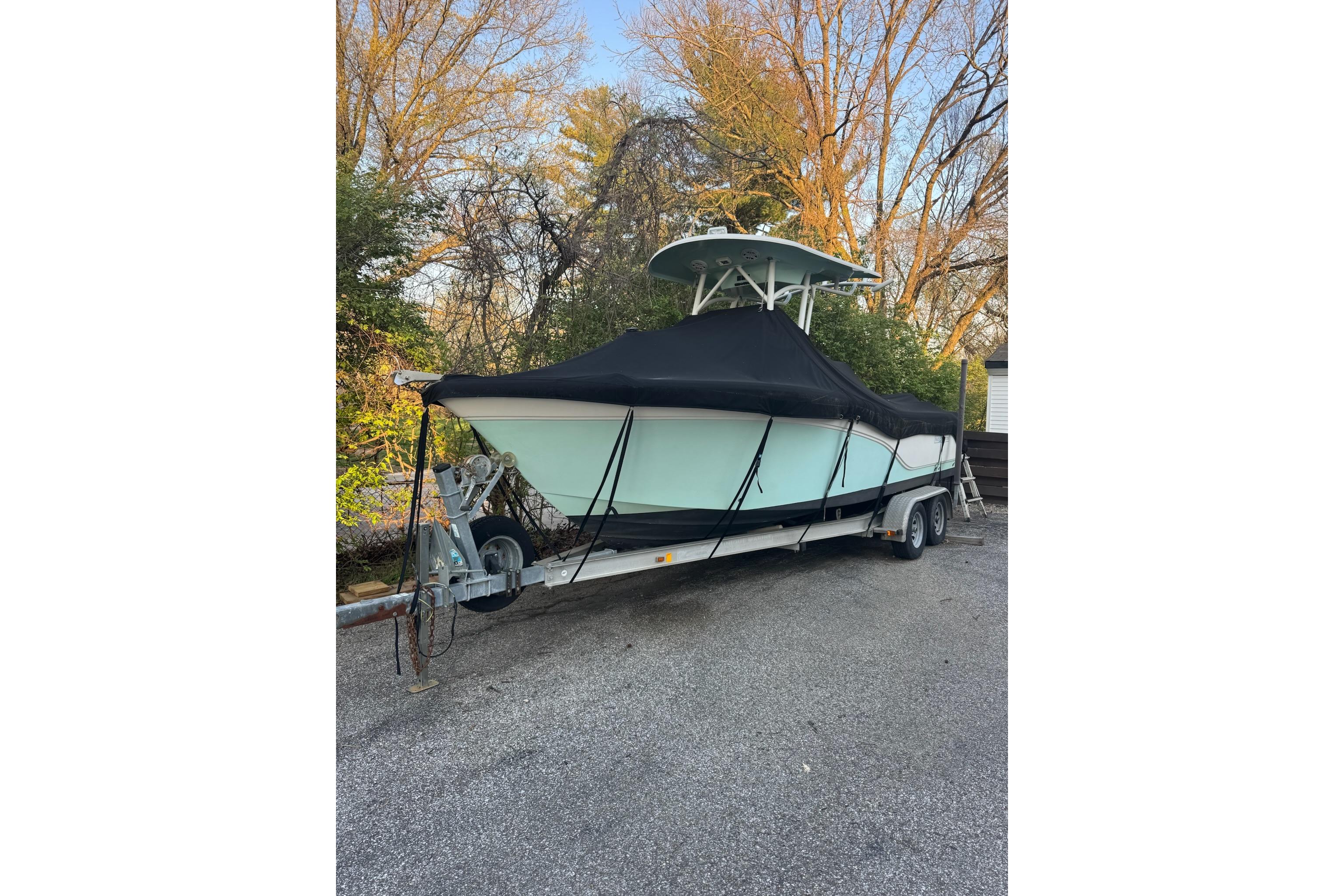 2013 Sea Fox 246 Commander boat on trailer, covered, parked outdoors.