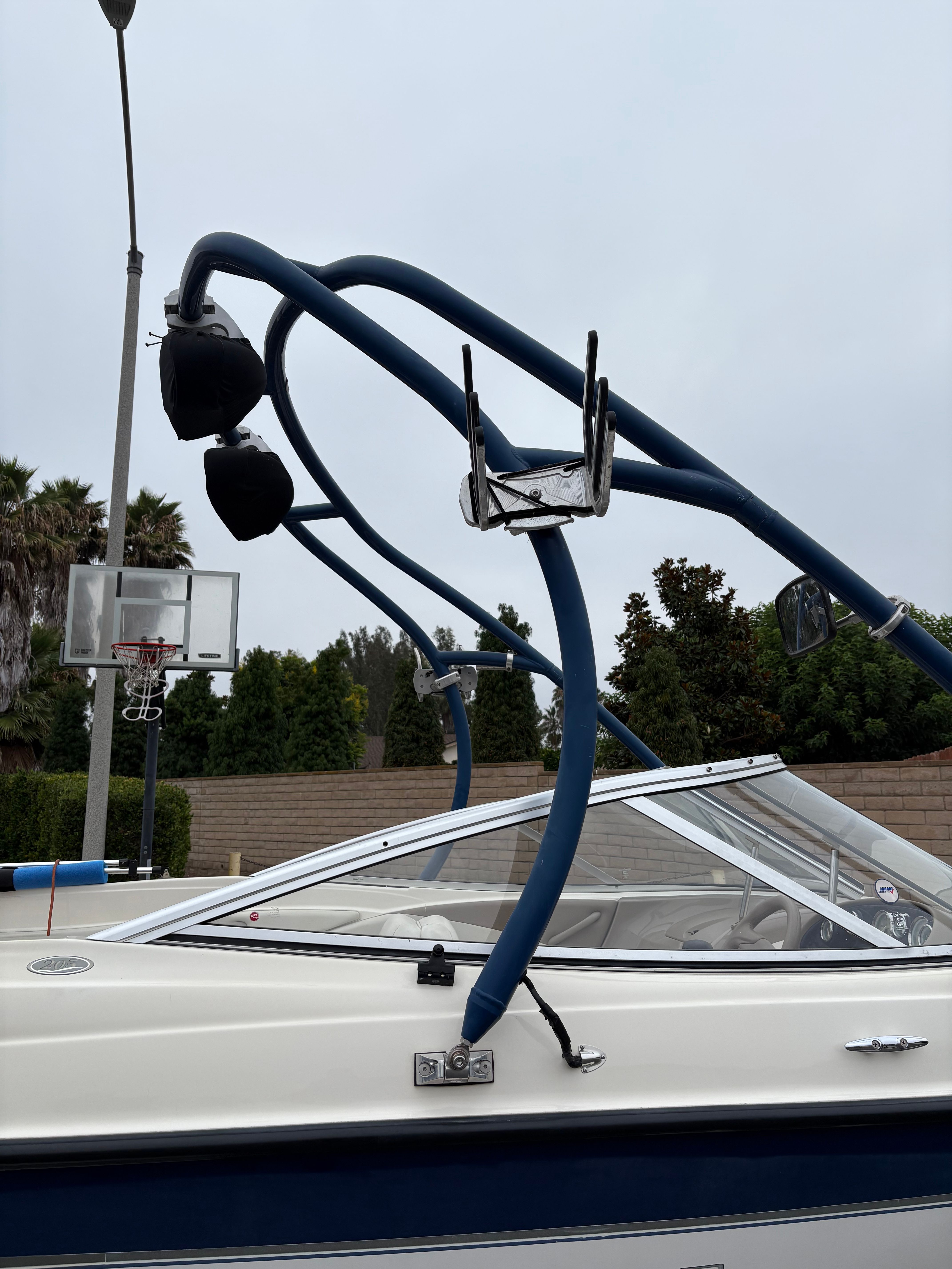 2003 Bayliner CAPRI 205 boat with blue wakeboard tower and speakers.