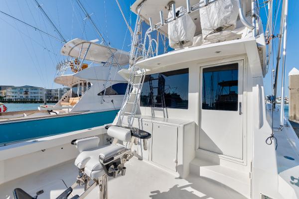 1999 Viking 47 Convertible yacht with fishing equipment and ladder, docked in a marina.