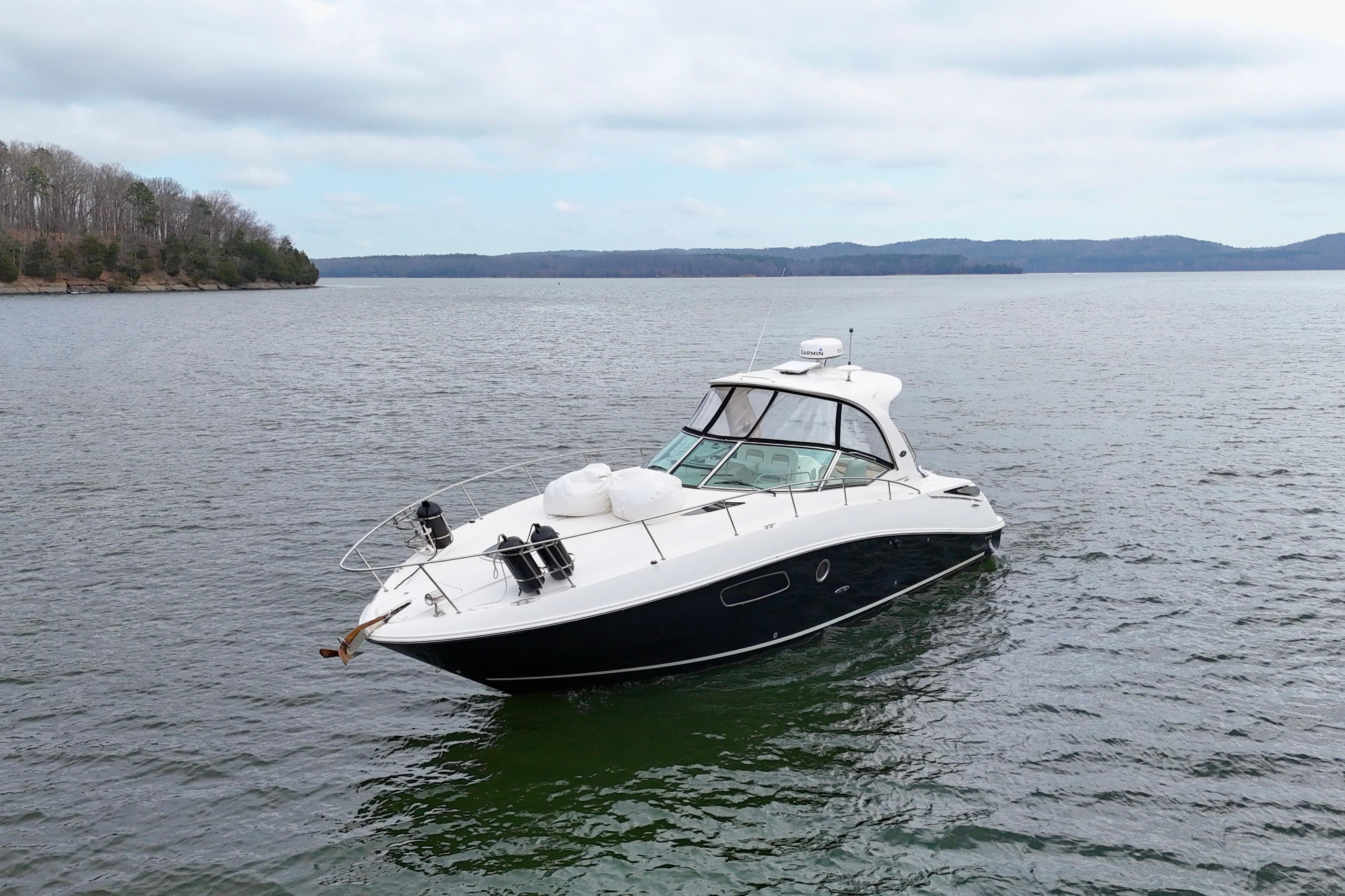 2009 Sea Ray Sundancer 350 yacht on calm lake waters, surrounded by scenic landscape.
