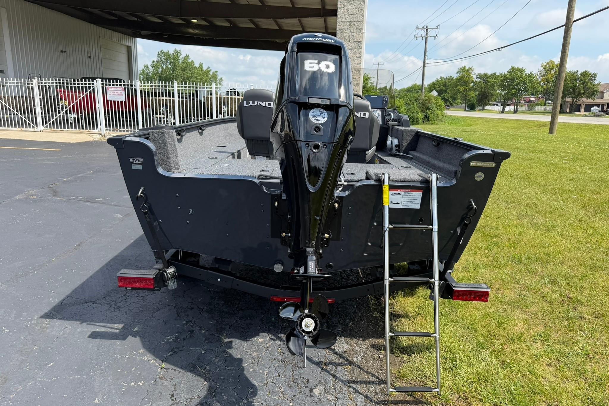 2027 Lund 1650 Rebel XL SS boat with Mercury 60 engine, parked outdoors.