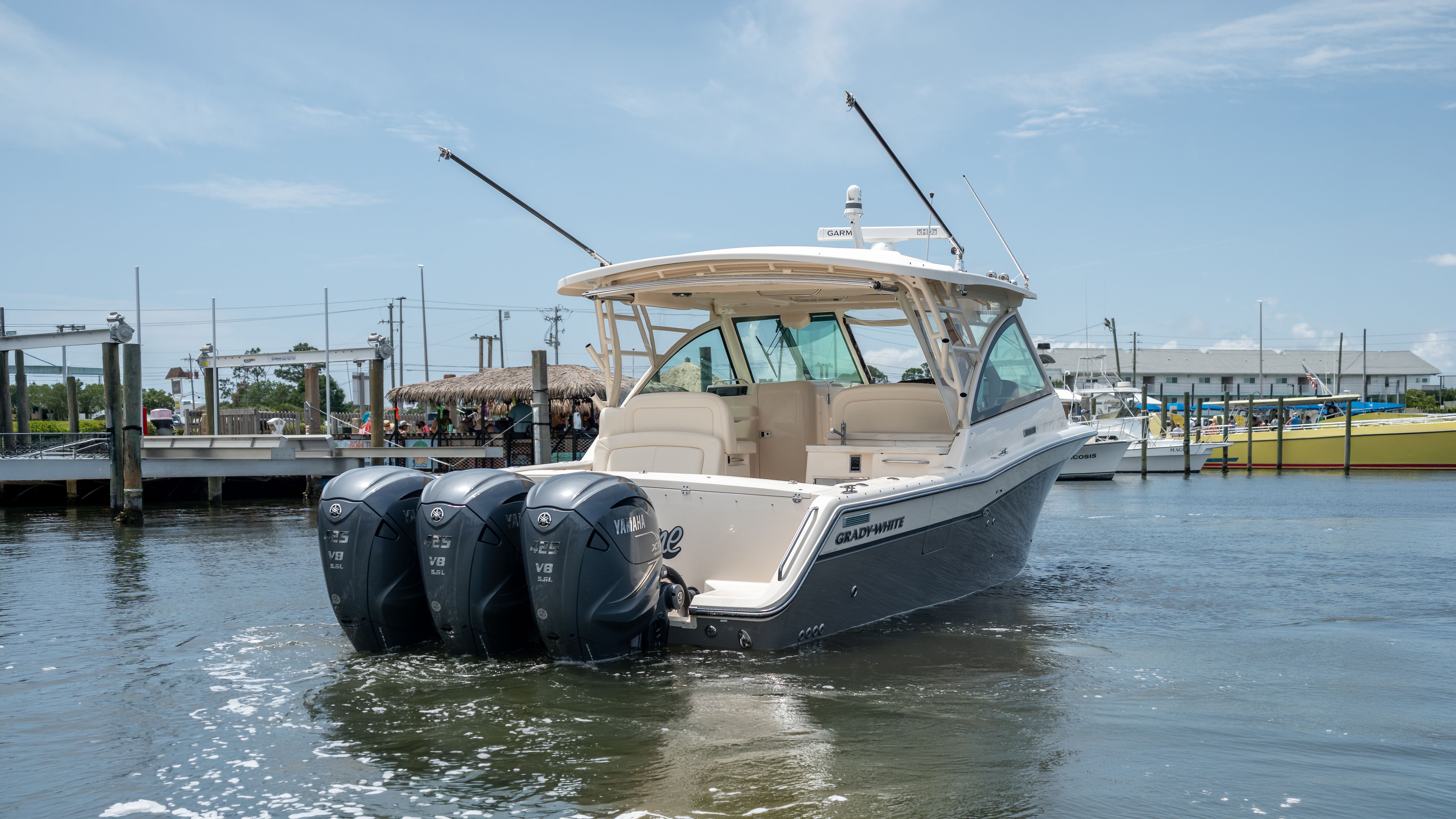 2019 Grady-White 375 Freedom with three outboard engines, in the water near a dock.