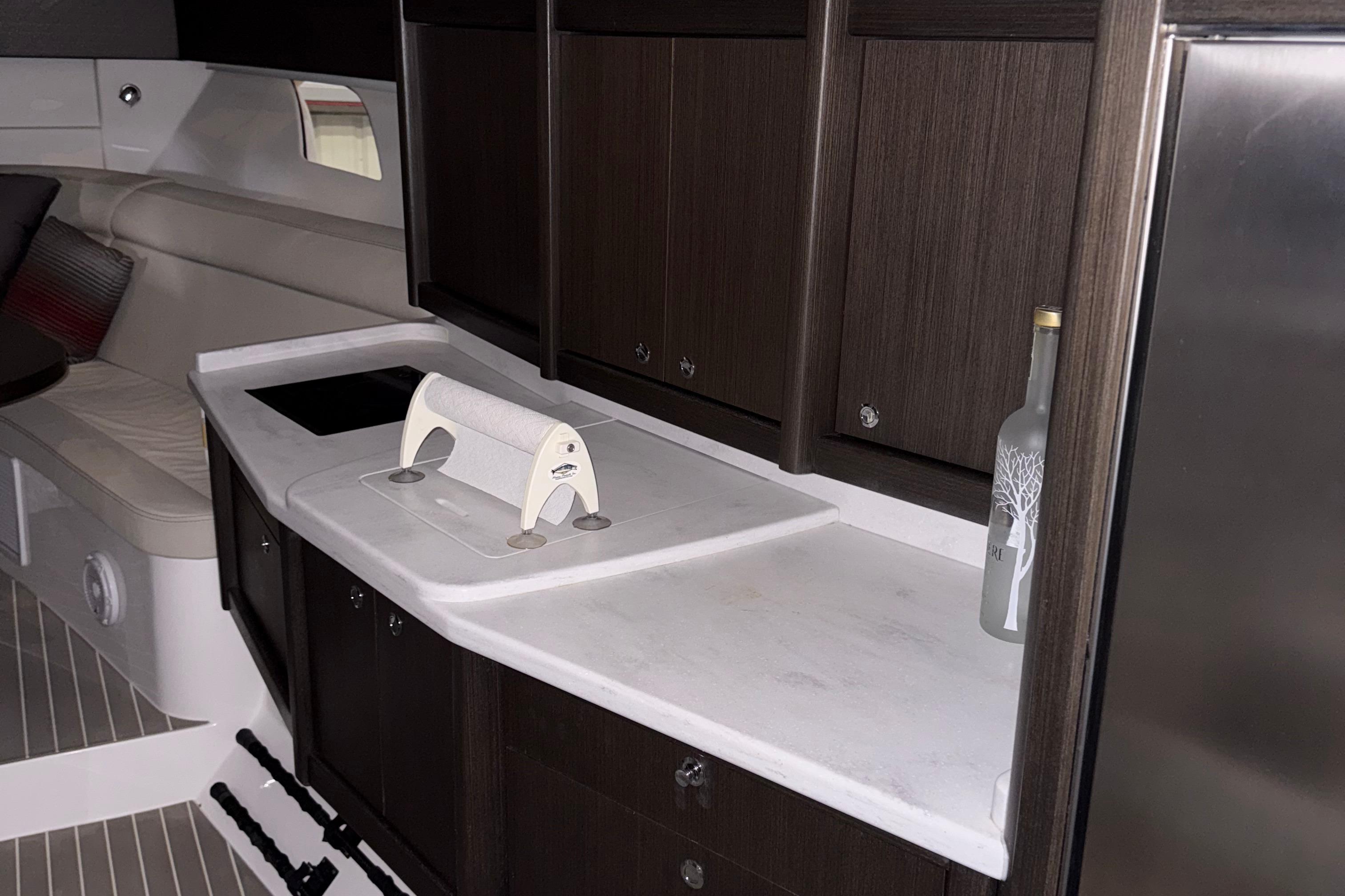 Luxurious interior of 2020 Intrepid 475 Sport Yacht with modern kitchenette and seating area.