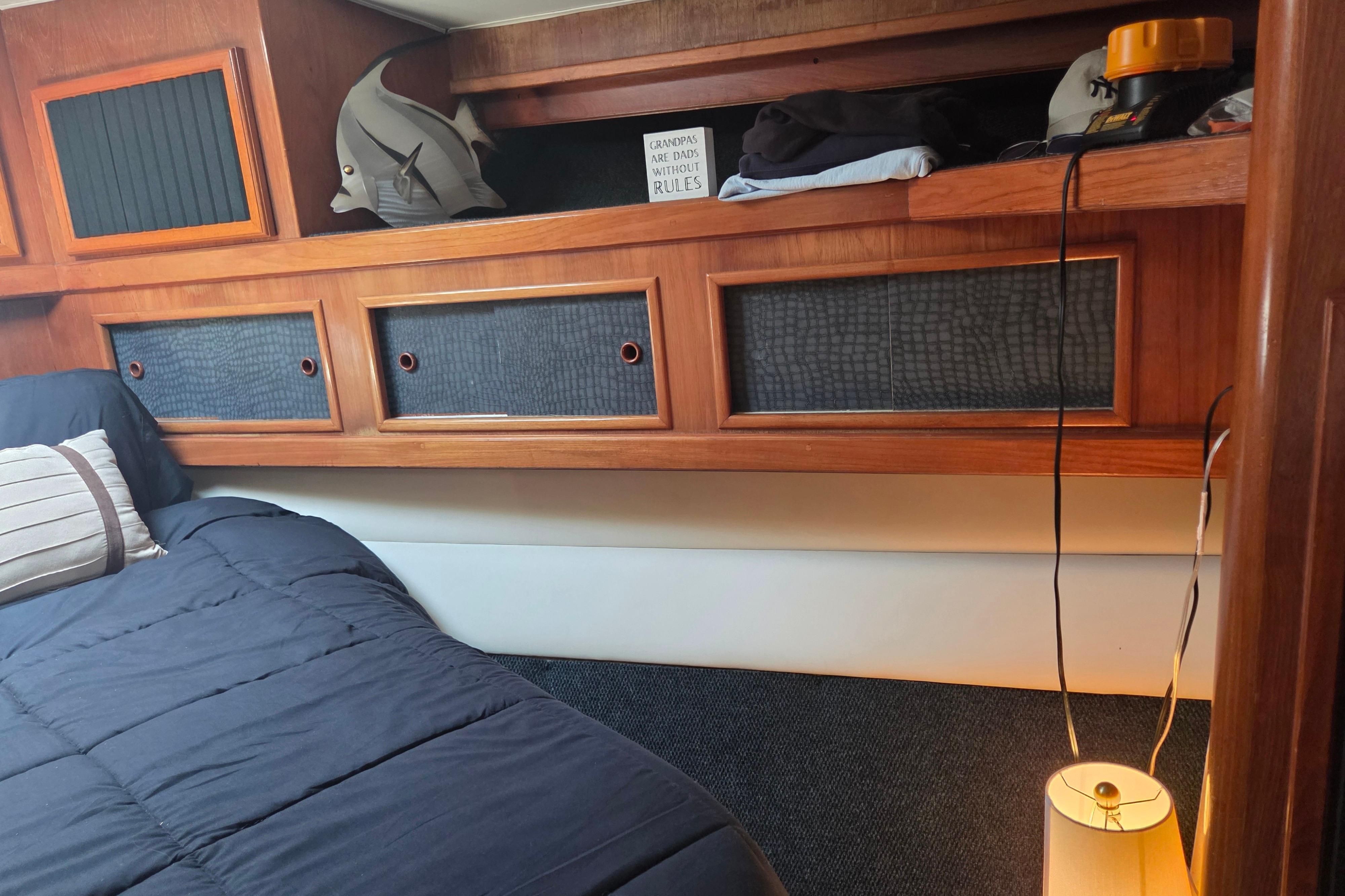 Cozy cabin interior of 1990 Egg Harbor Golden Egg 42 yacht with wooden storage and bedding.
