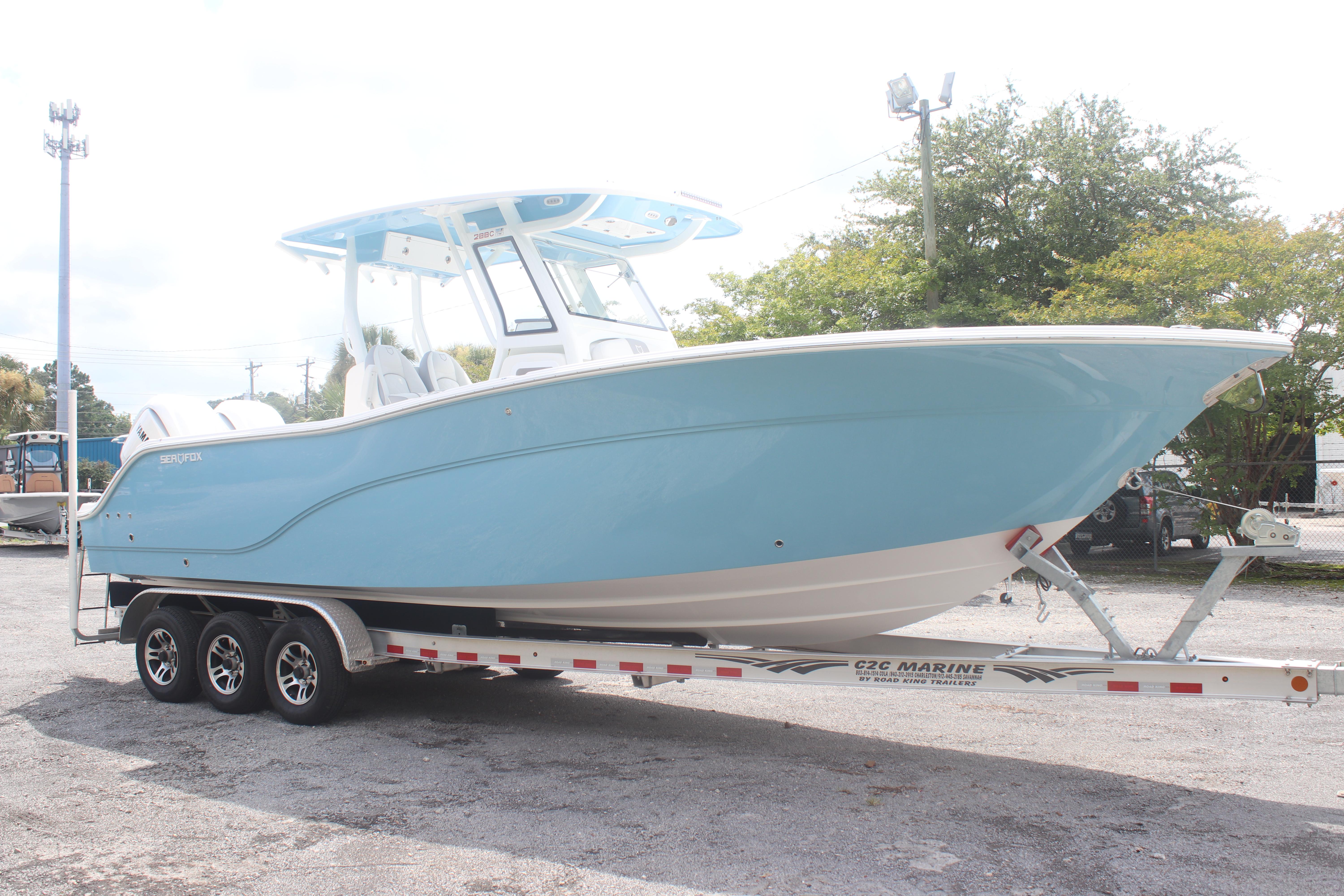 2026 Sea Fox 288 Commander boat on trailer, light blue hull, parked outdoors.