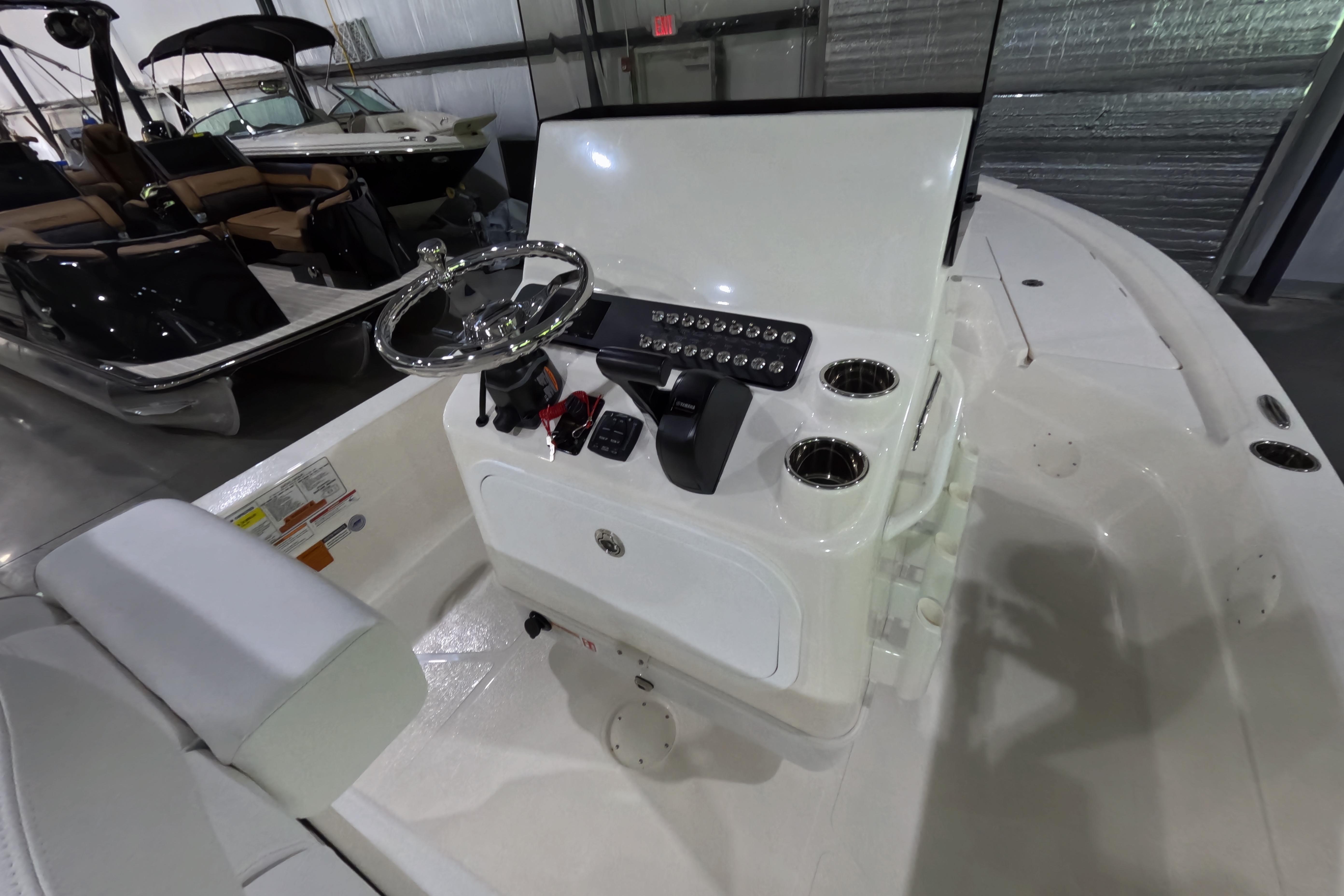 2026 Skeeter SX221 boat interior with steering console and controls in showroom.