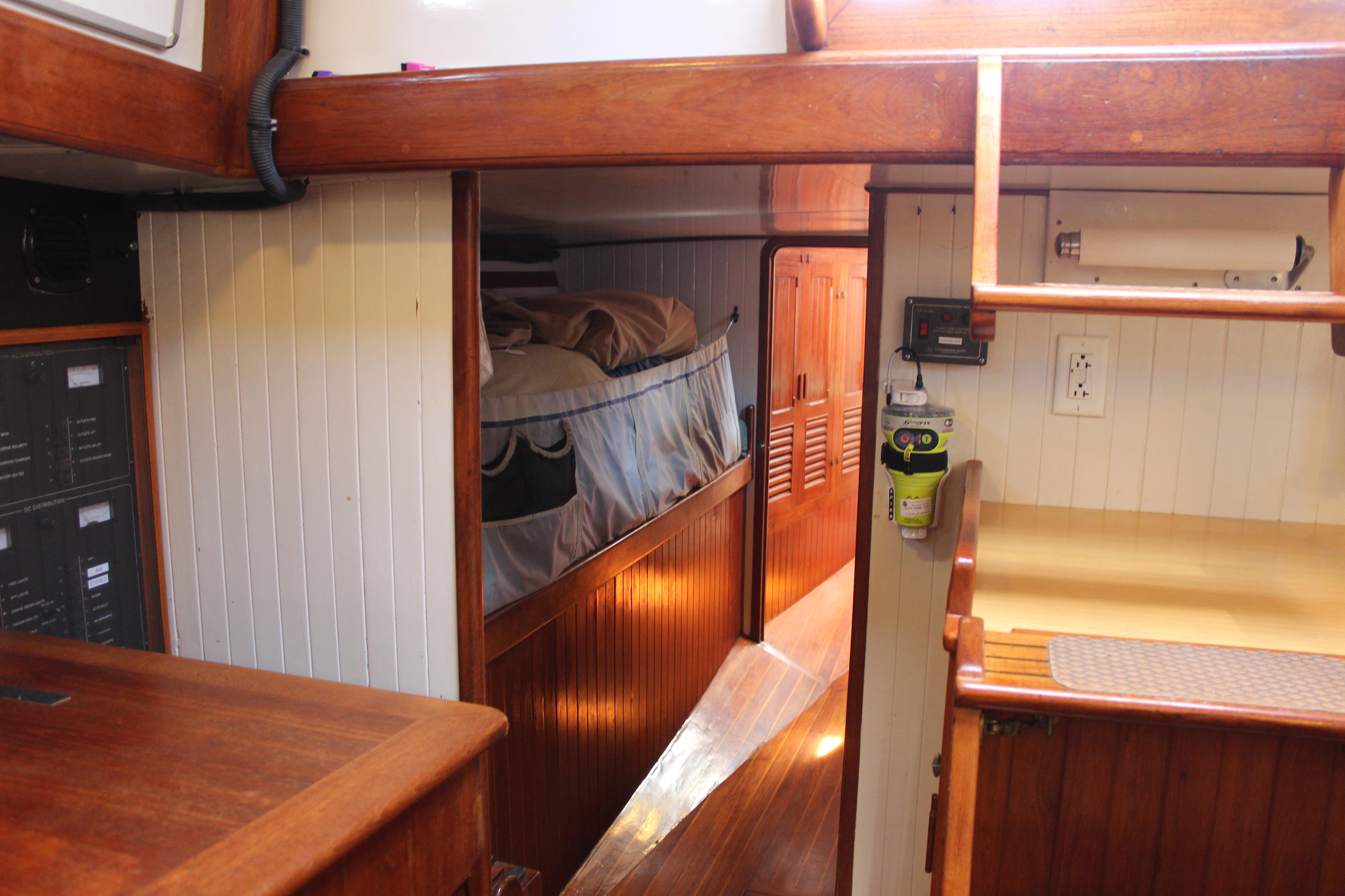 Interior of 1981 Kelly Peterson 46 sailboat, featuring cozy wooden cabin and sleeping area.