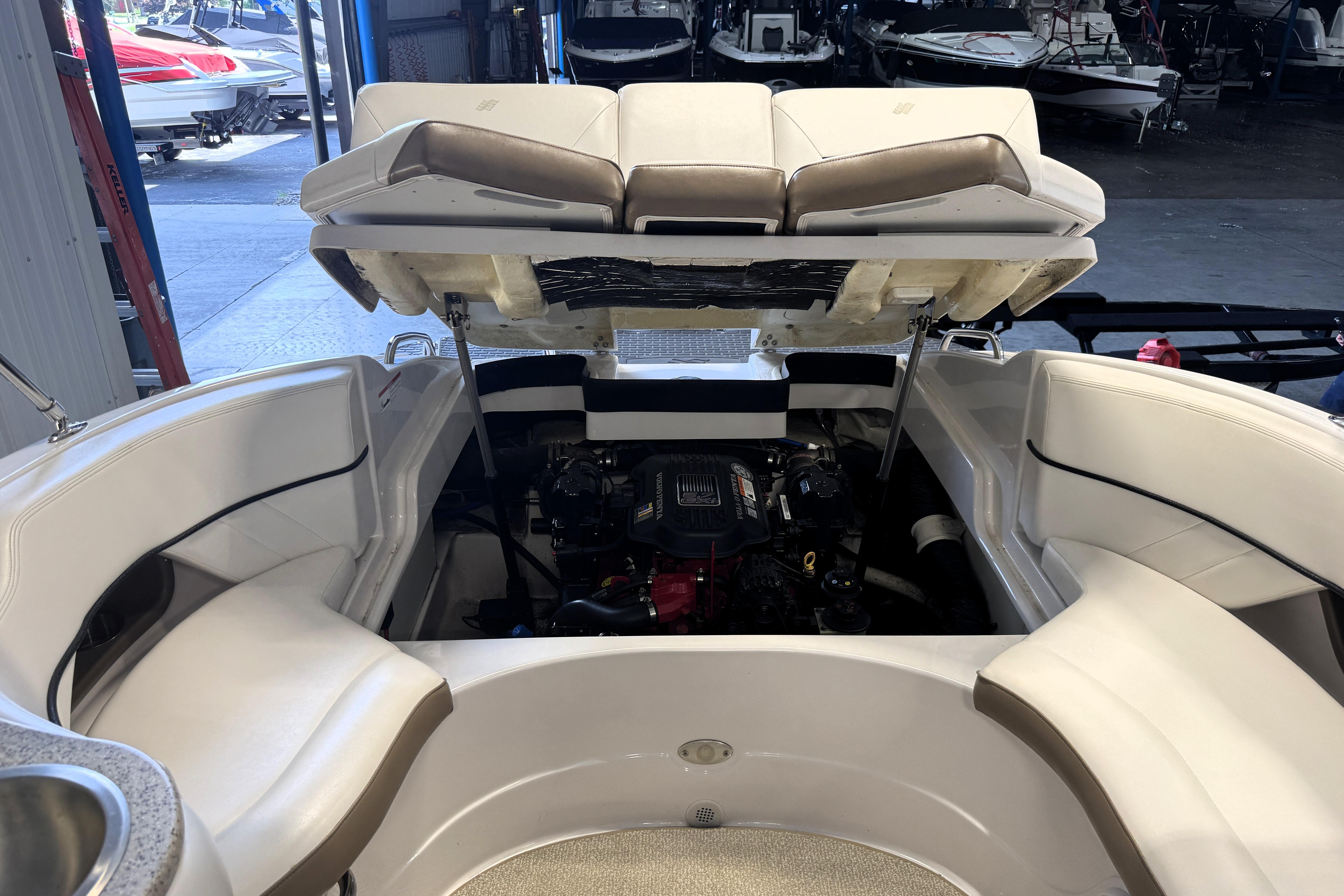 2008 Four Winns H240 boat interior with open engine compartment in a showroom.