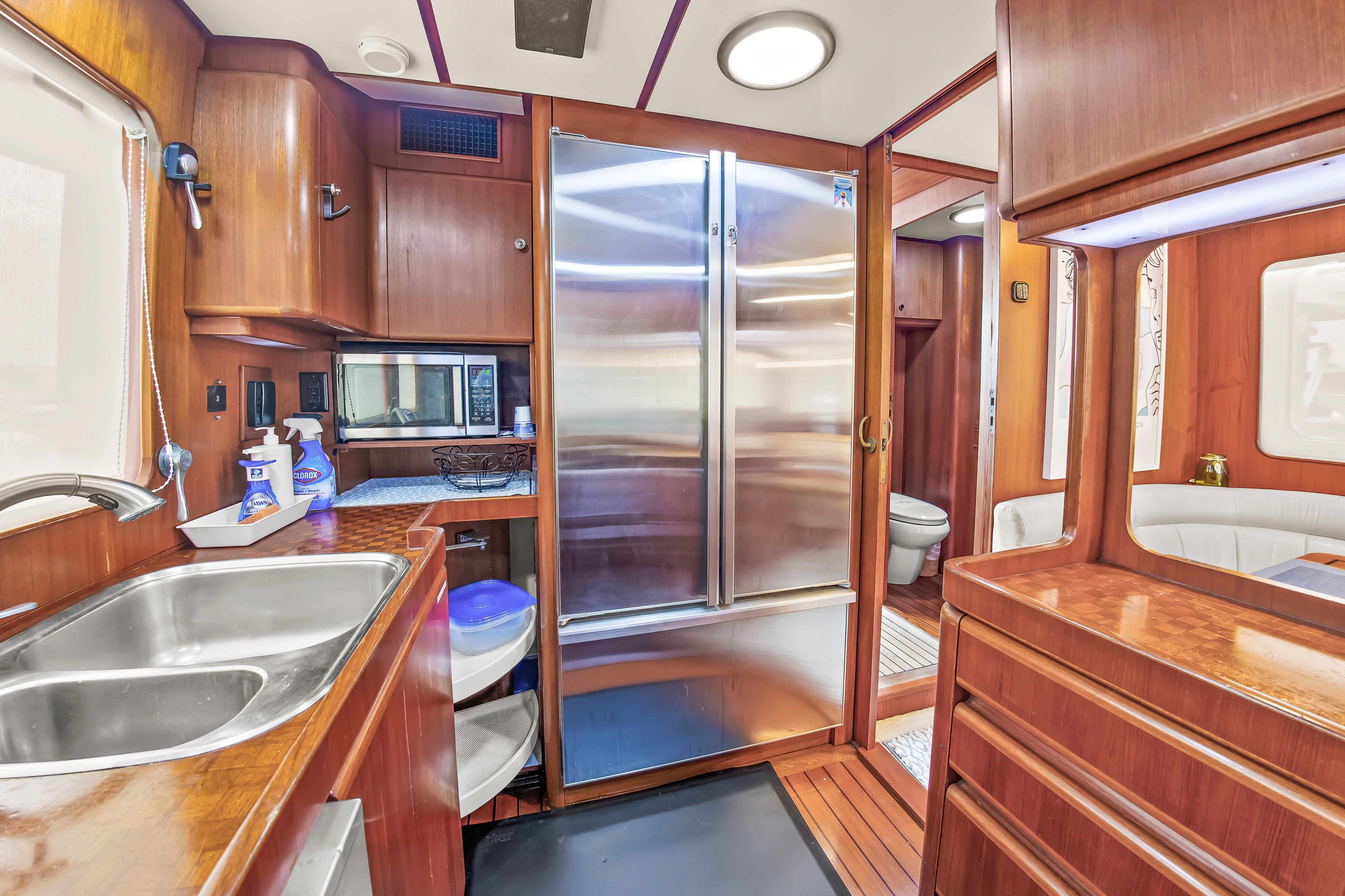 Interior of a 1987 Jongert 78 Motor Yacht with wooden furnishings and stainless steel appliances.