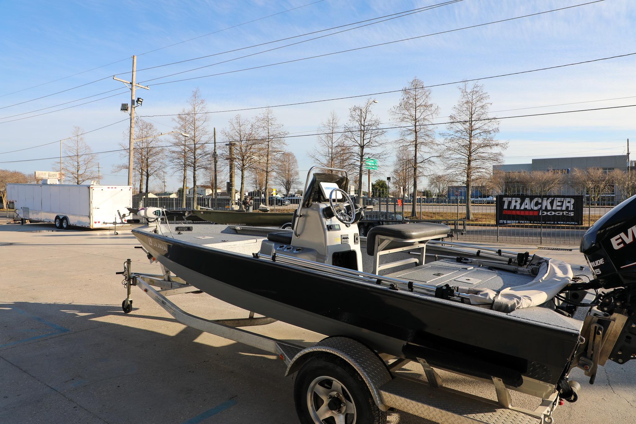 2019 Express 18 boat on trailer, parked outdoors near trees and trailers.