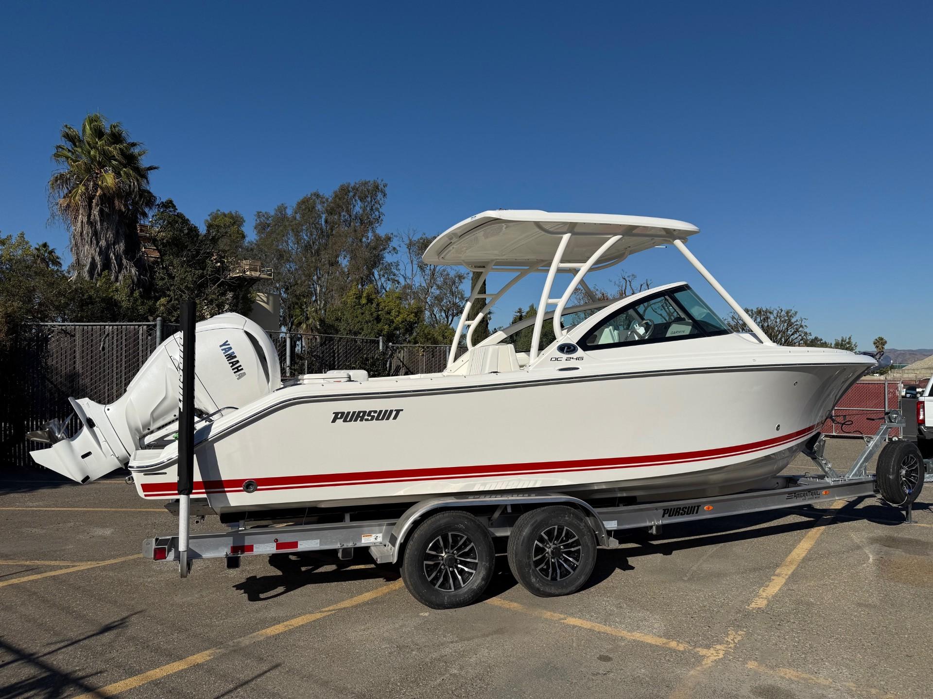 2025 Pursuit DC 246 Dual Console boat on trailer, parked outdoors.