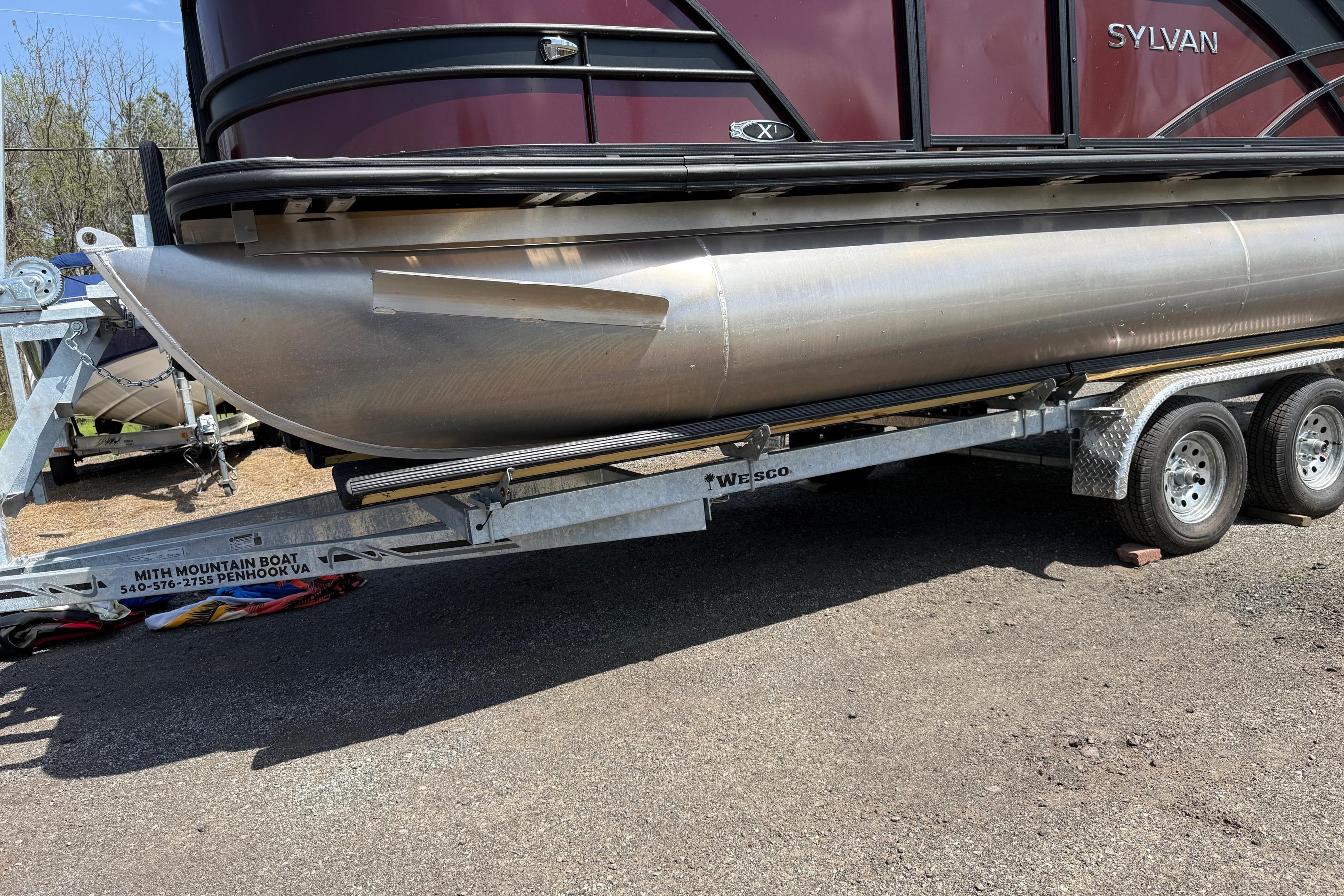 2024 Sylvan X1 CLZ DH pontoon boat on trailer, side view.