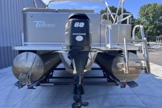 2012 Avalon Tahoe pontoon boat with outboard motor, docked outdoors.