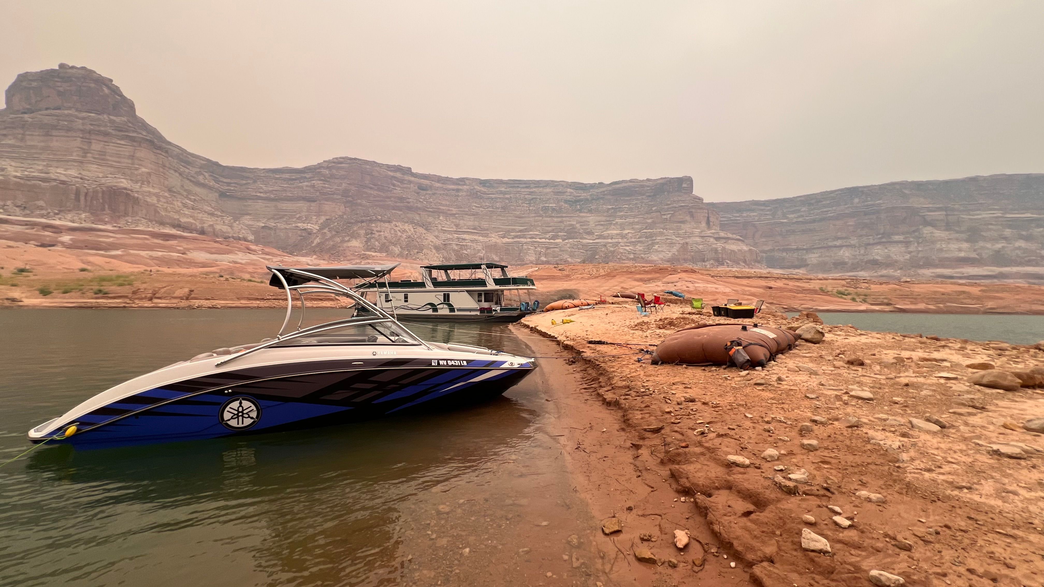 Yamaha AR240 HO boat by a lake shore with rocky cliffs in background.