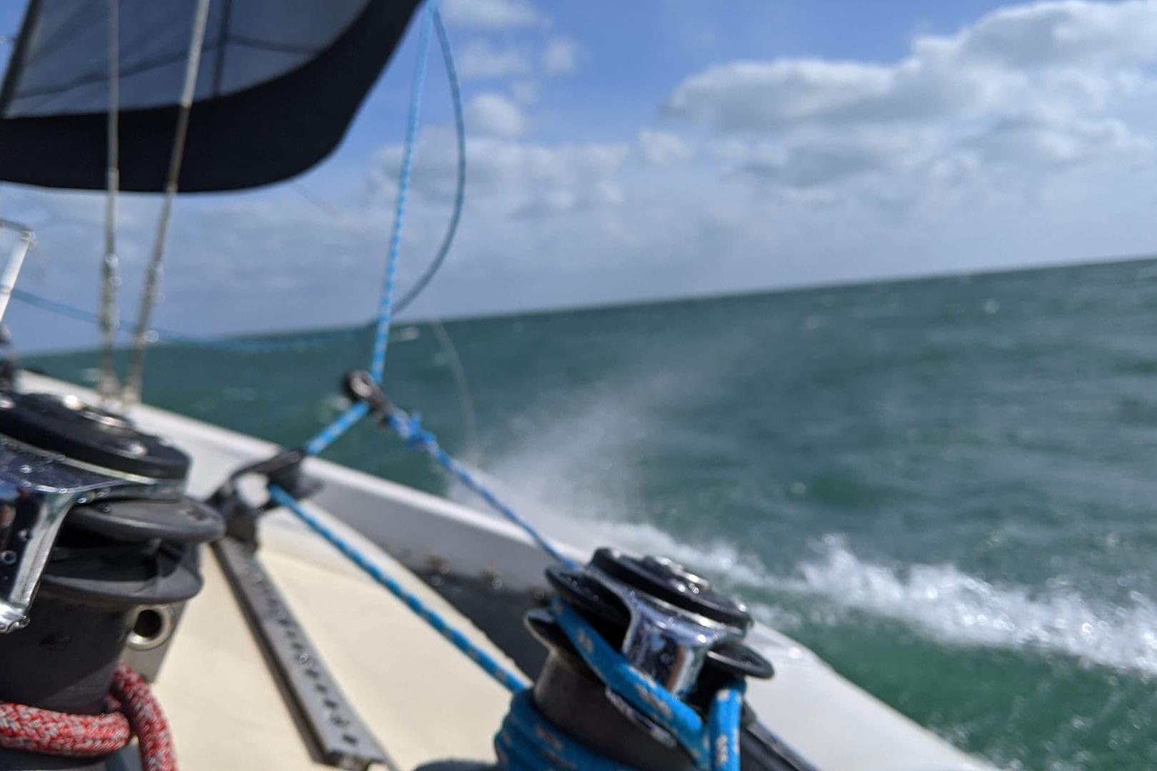Sailing on a 1991 Corsair F-27 trimaran, ocean waves and blue sky in view.