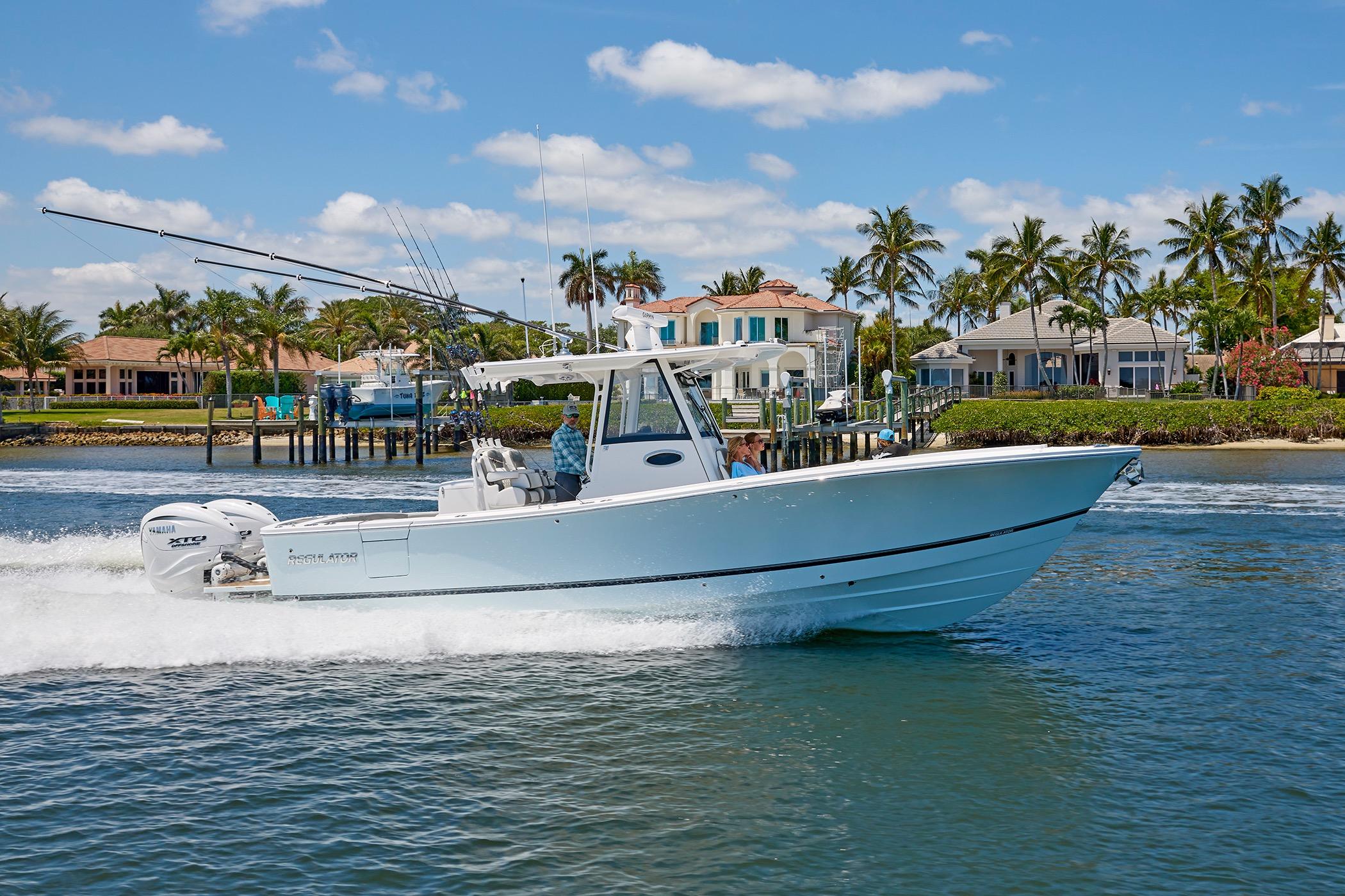 2025 Regulator 31 boat cruising on water near waterfront homes and palm trees.