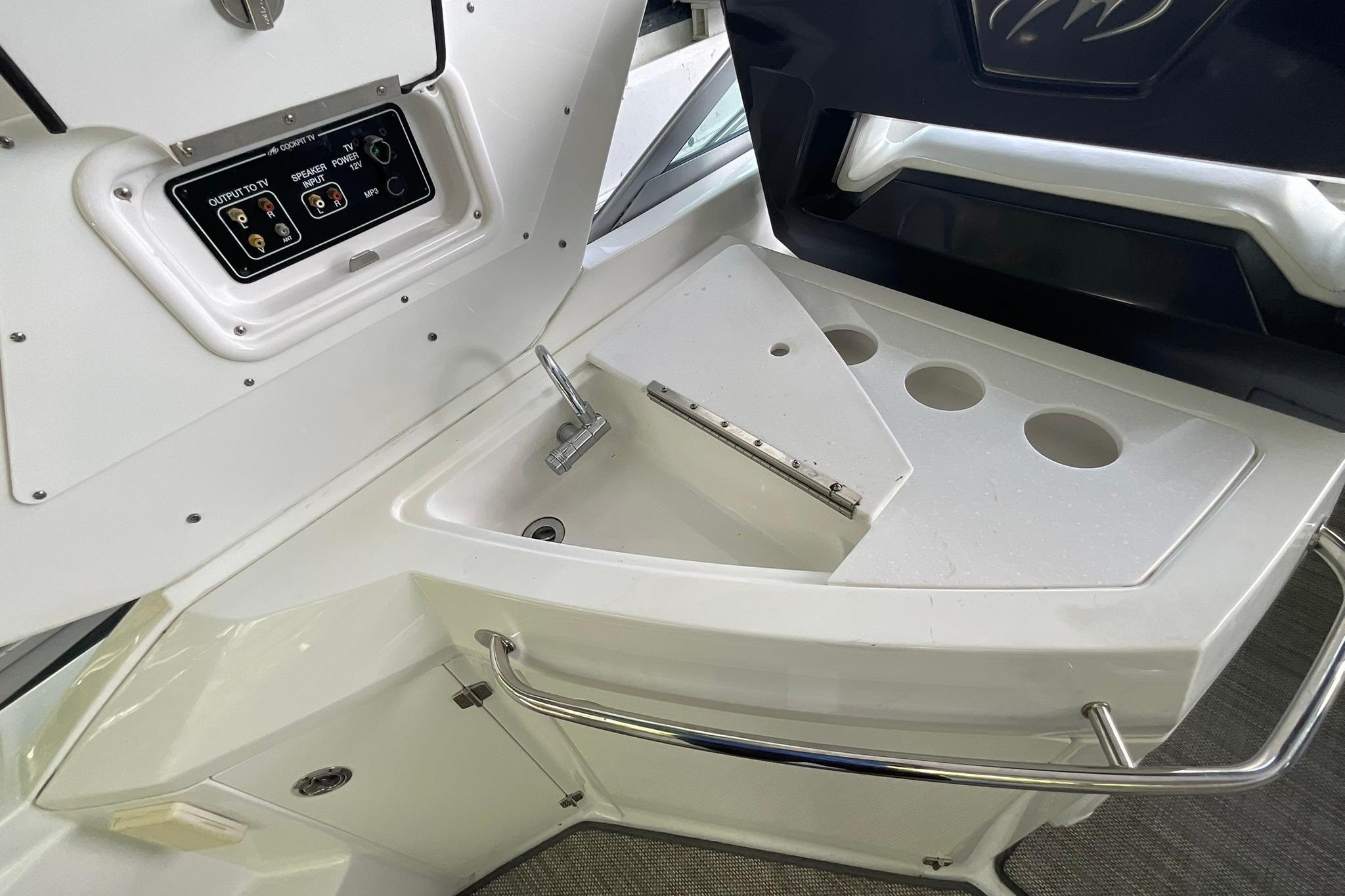 2019 Monterey 335 Sport Yacht cockpit sink with control panel and cup holders.