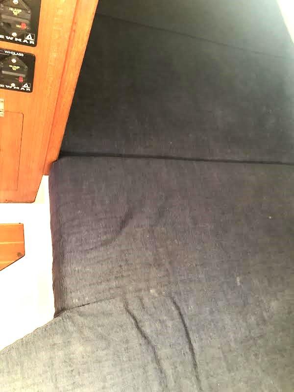 Interior of 1990 Hunter Vision 32 sailboat with dark fabric and wooden paneling.