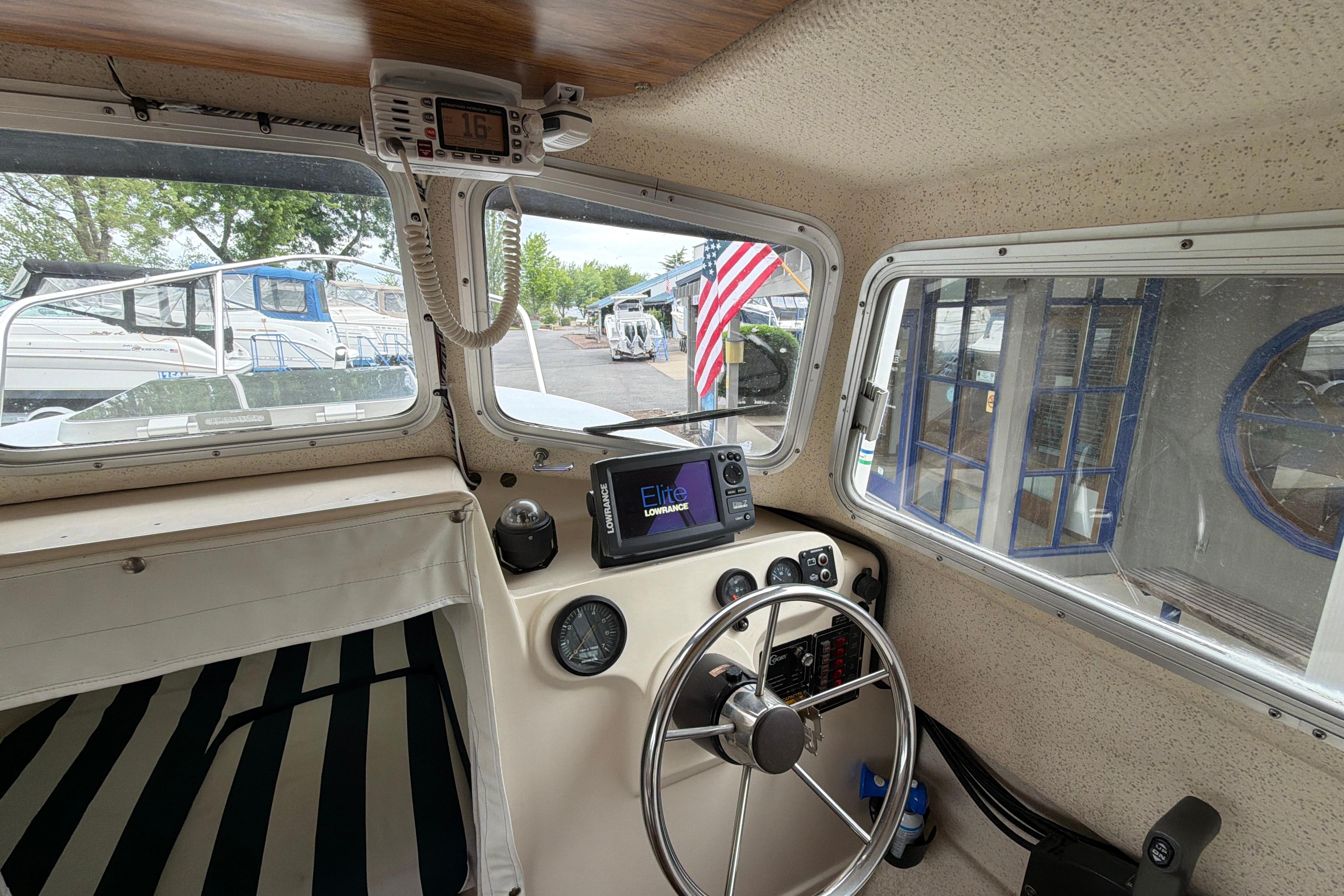 Interior view of a 1989 C-Dory 22' Angler boat cockpit with steering wheel and navigation equipment.