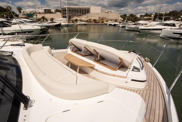 Luxurious 2024 Princess V55 yacht with elegant deck seating in a marina setting.