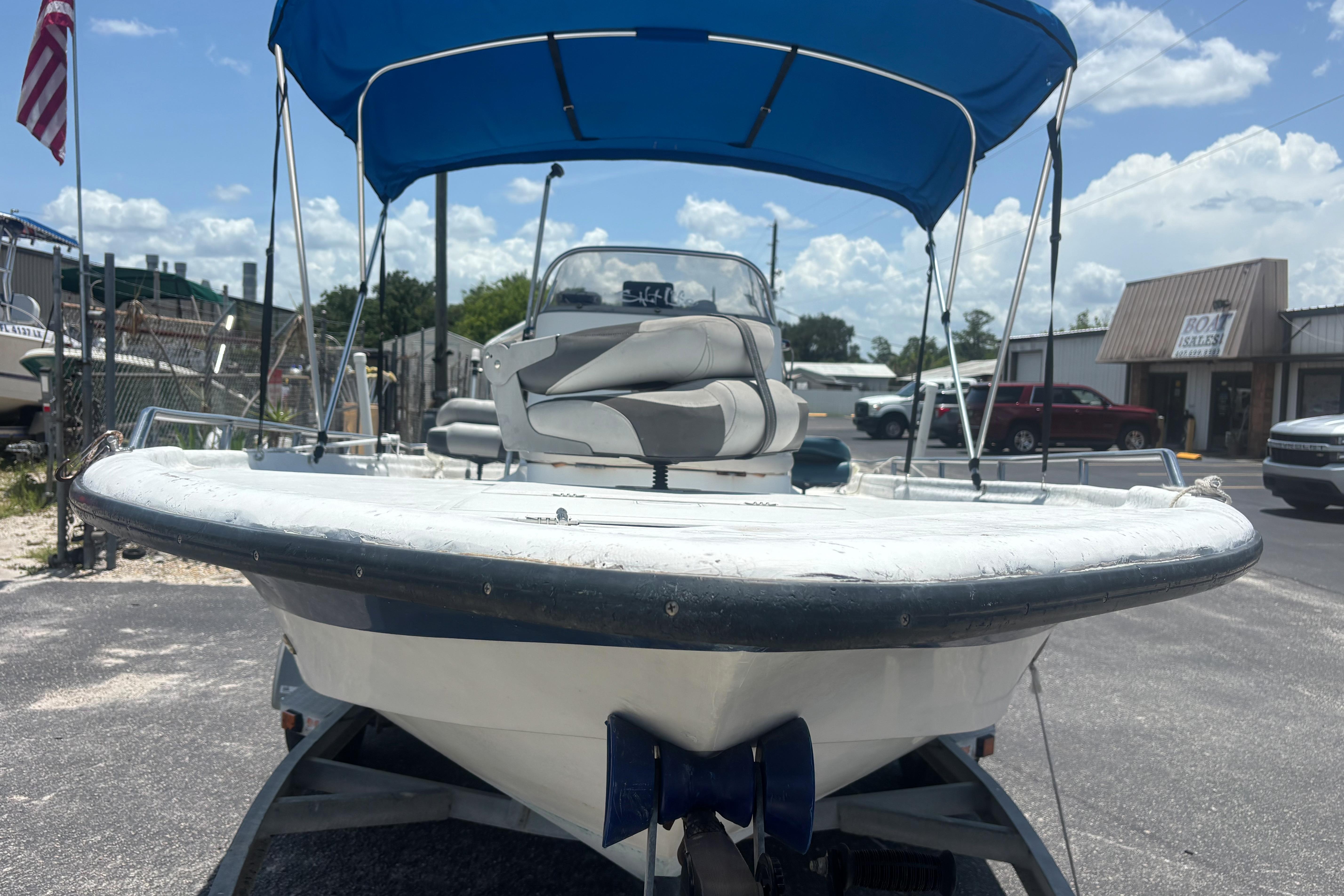 2000 VIP 1880 Bay Stealth boat with blue canopy, parked outdoors on a sunny day.