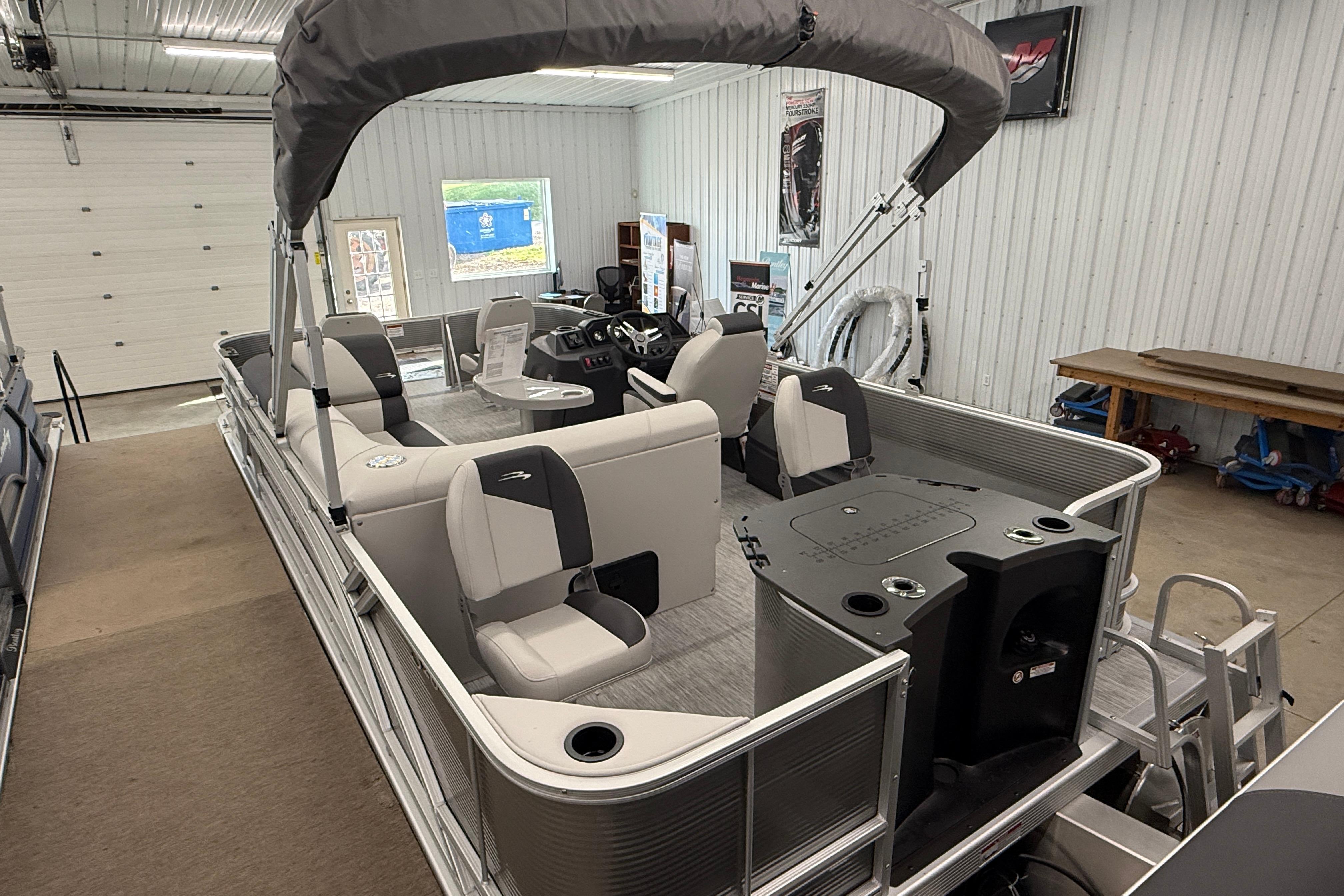 2026 Bennington 20 SF pontoon boat in a showroom, featuring modern seating and helm.