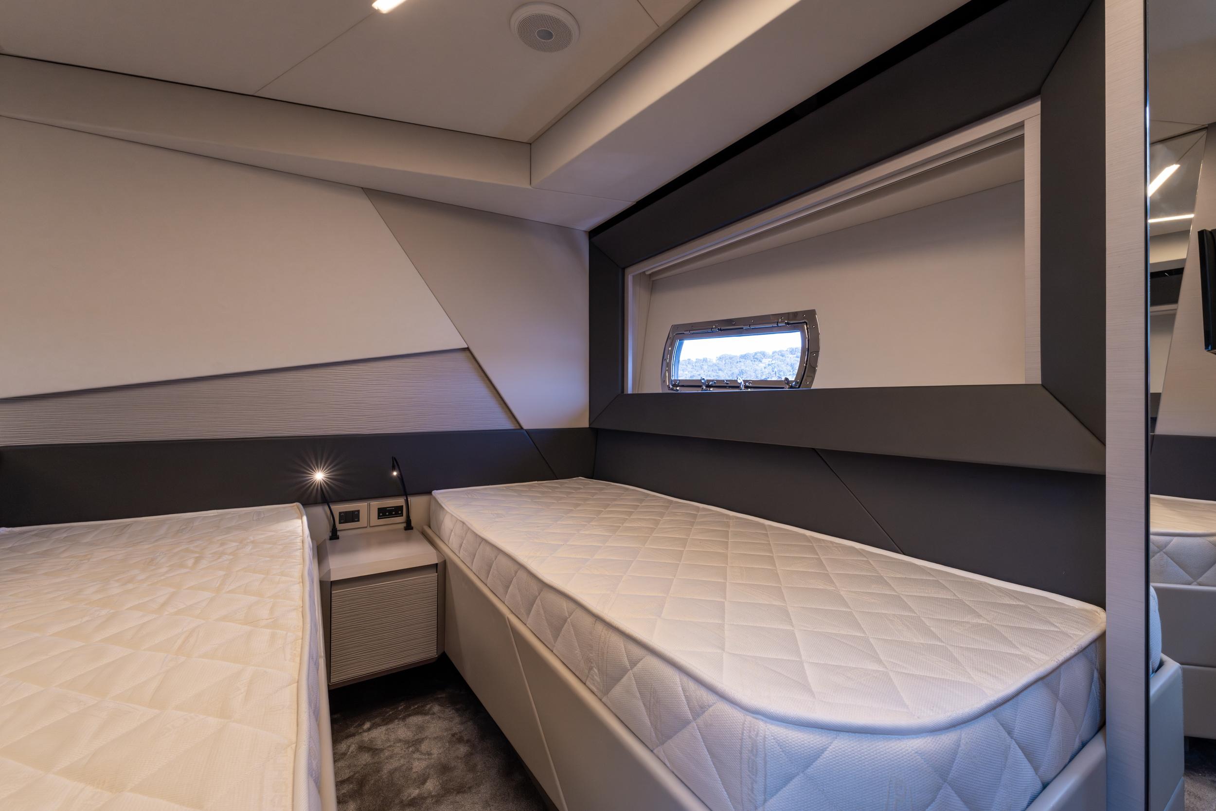 Luxurious twin cabin interior of 2024 Pershing 7X yacht, featuring modern design and comfortable bedding.