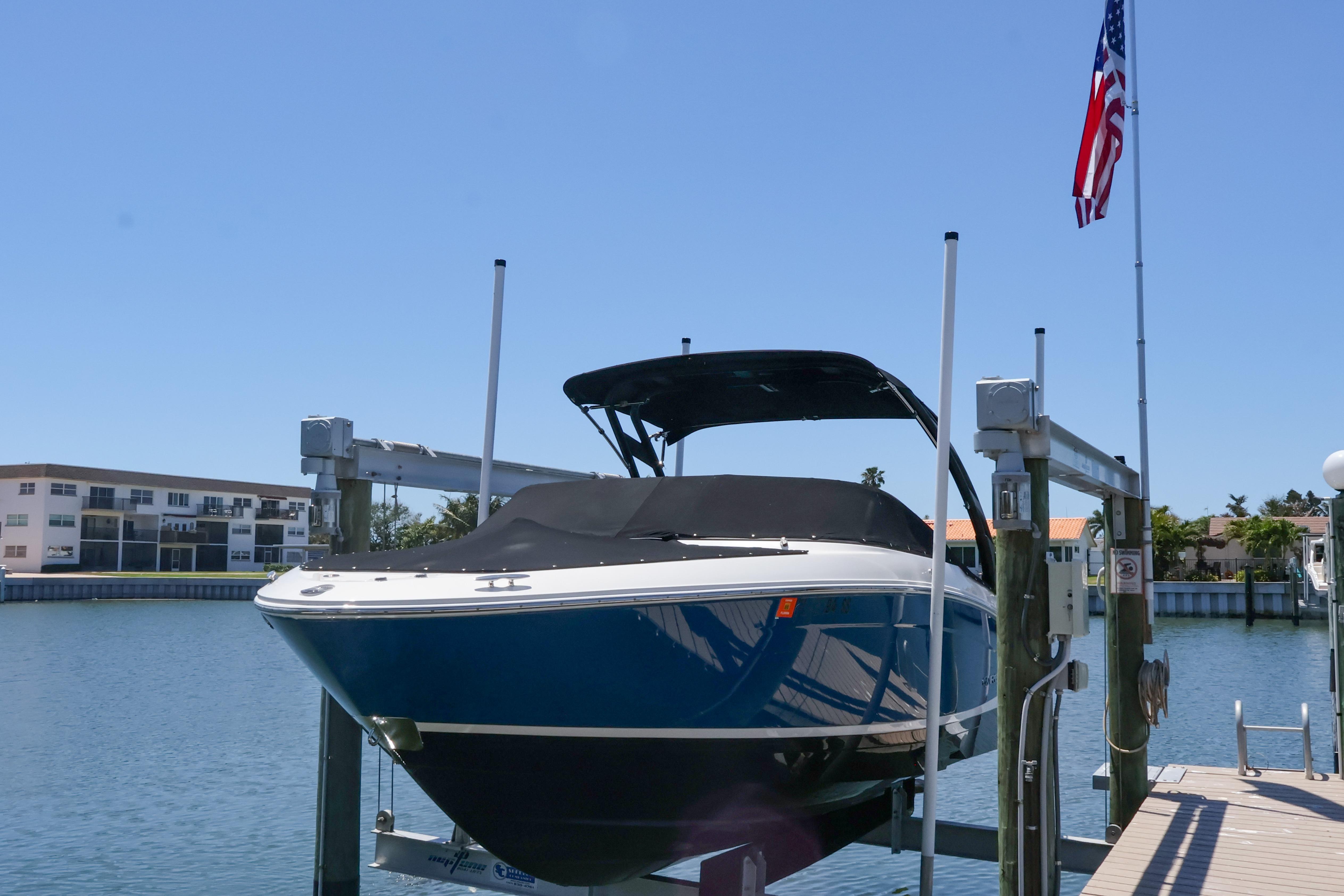 2020 Regal LX4 boat docked on lift with American flag in background.