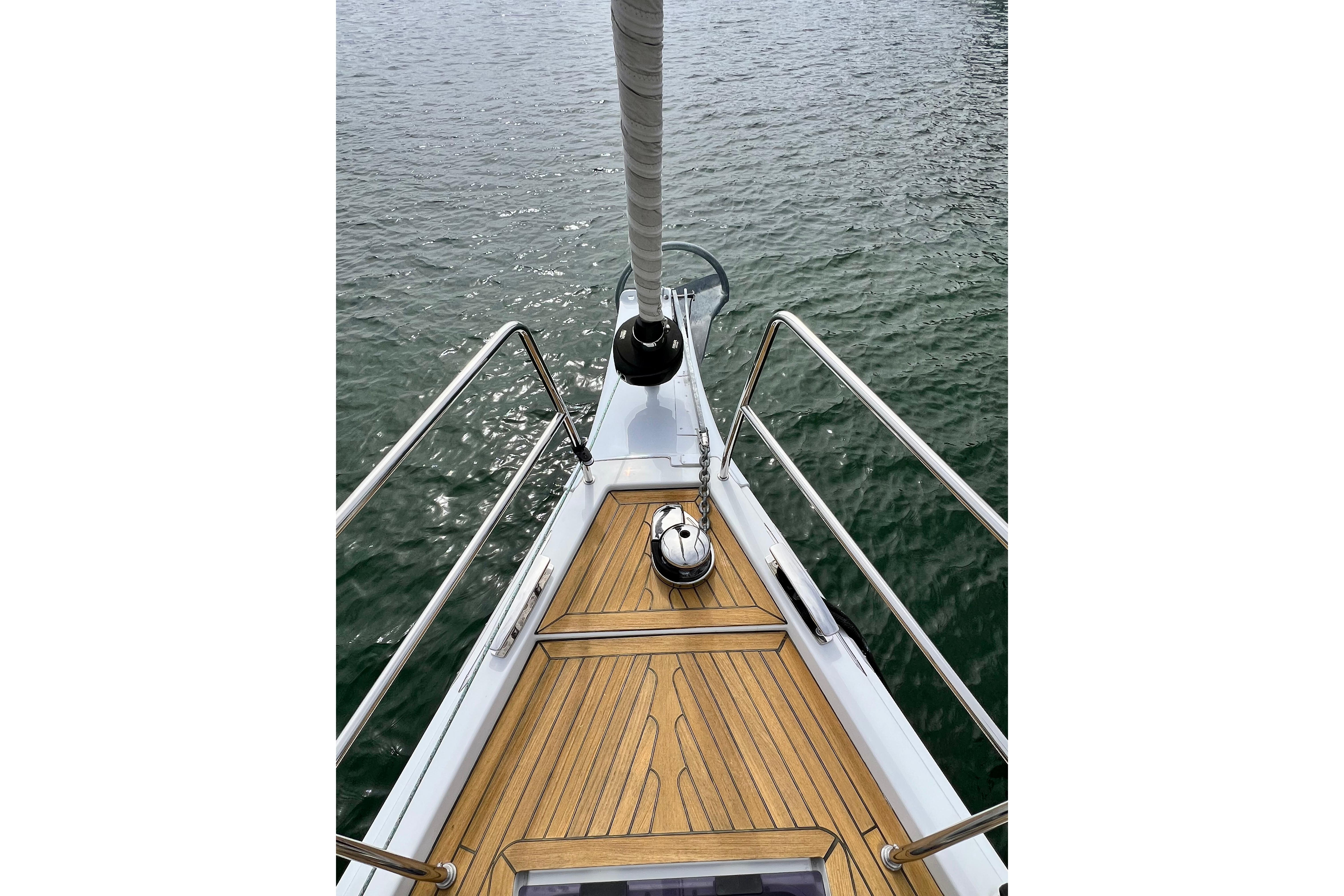 Bow of 2016 Hanse 455 yacht with teak deck and stainless steel railings.