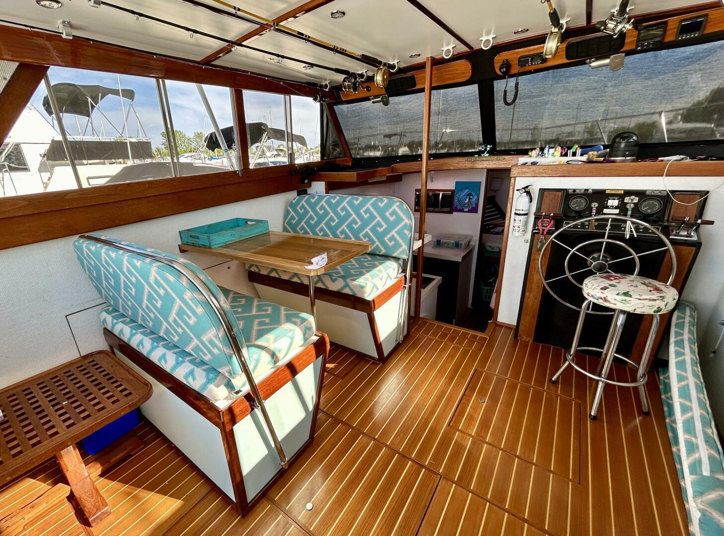 1980 Viking Convertible boat interior with wood flooring, patterned seating, and helm station.