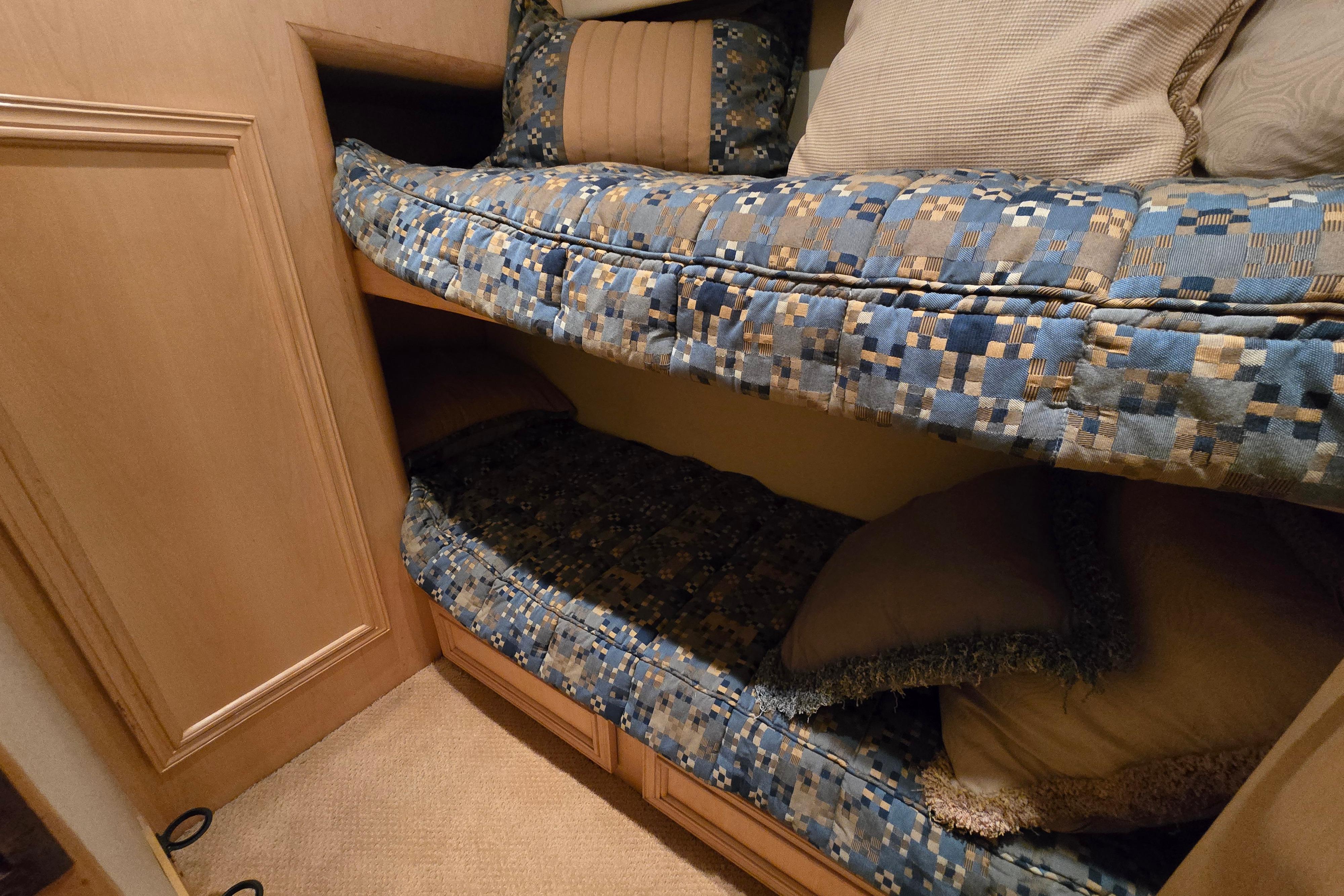 Bunk beds with blue patterned bedding in a 2001 Cavileer 53 Convertible yacht.