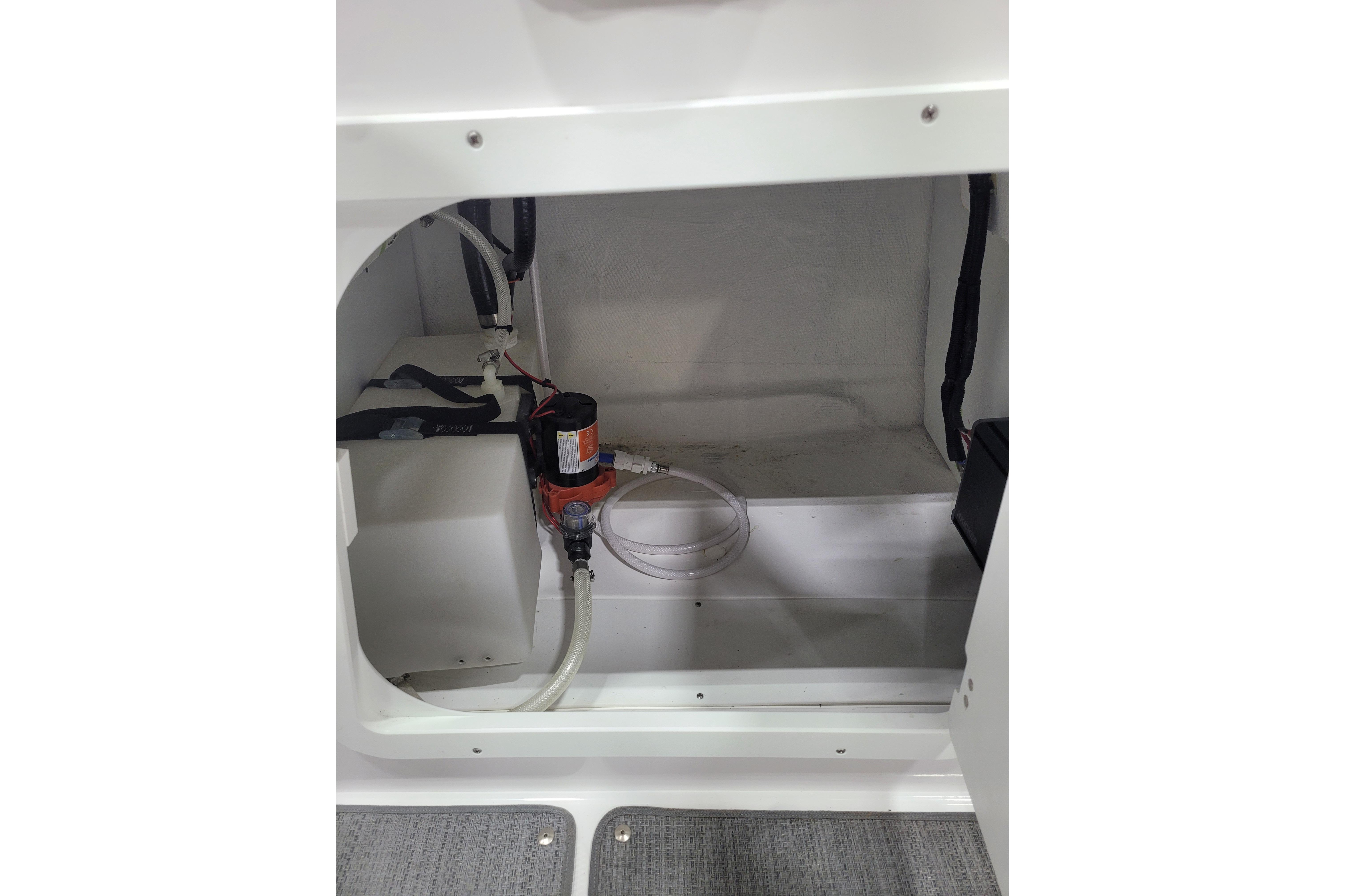 Interior view of 2026 Tahoe 2150 boat compartment with pump and wiring.