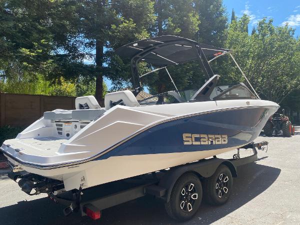 2025 Scarab 235 SE boat on trailer, parked outdoors.