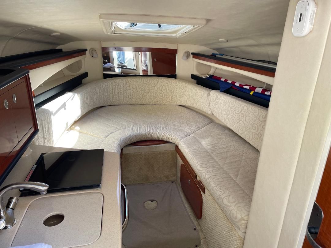 Interior of a 2005 Sea Ray Sundancer 260 with cozy seating area and small kitchenette.
