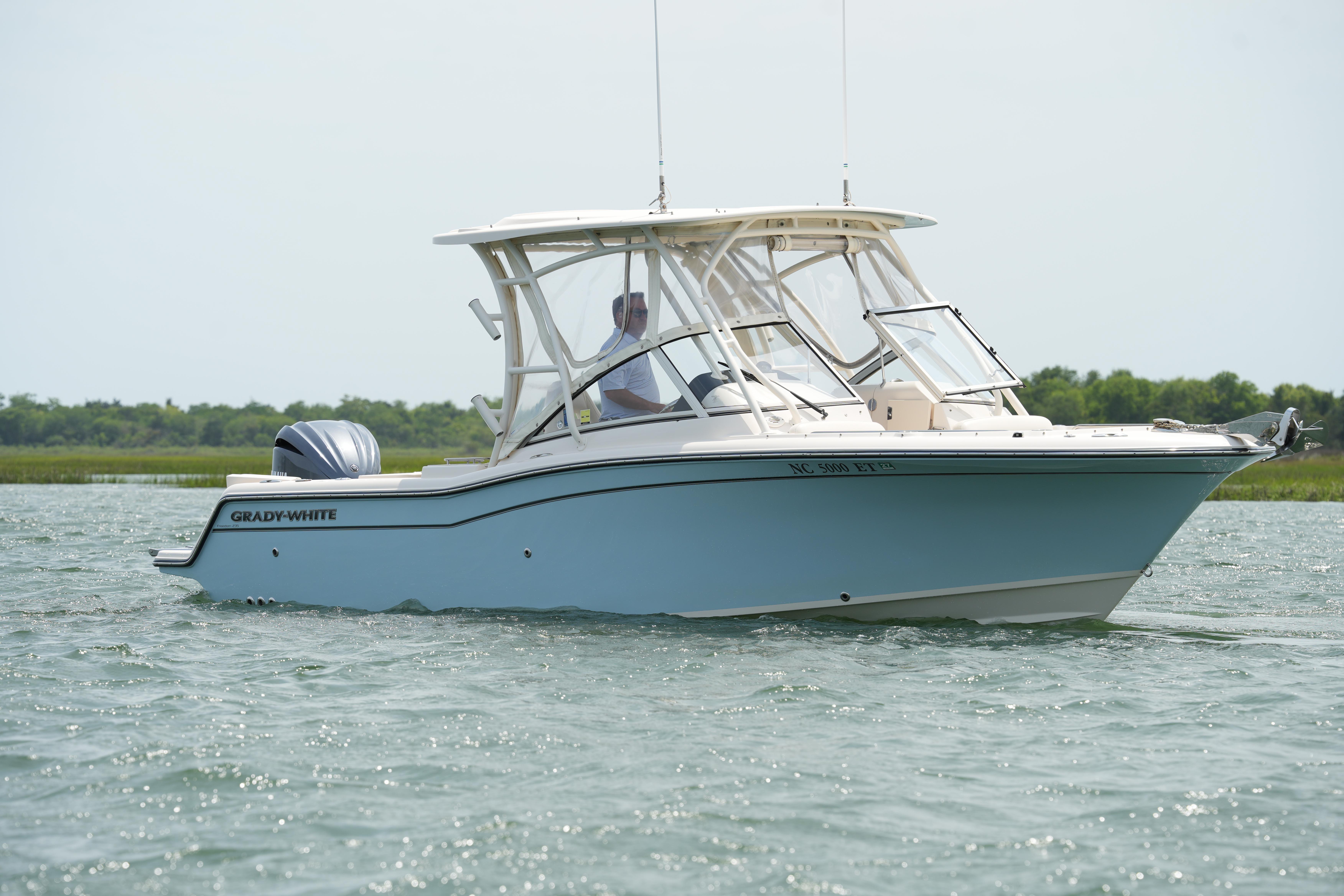 2021 Grady-White Freedom 235 boat cruising on calm waters.