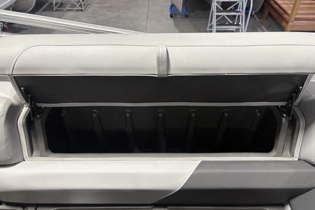 2026 Sun Tracker PARTY BARGE® 20 DLX storage compartment with open lid, showcasing interior space.
