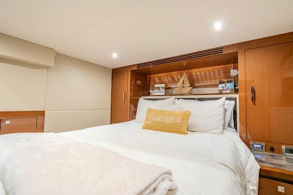 Luxurious bedroom interior of 2016 Sea Ray Sundancer 510 yacht with cozy bedding.