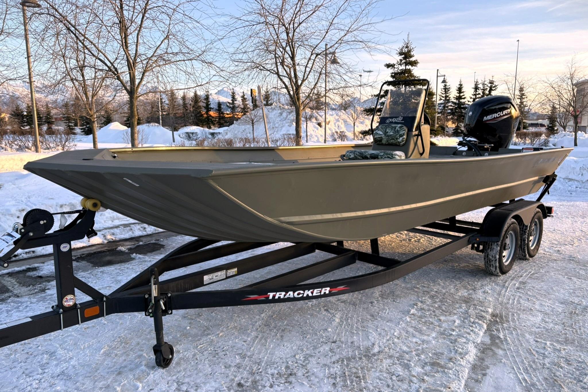 2024 Tracker Grizzly 2072 CC boat on trailer in snowy landscape.