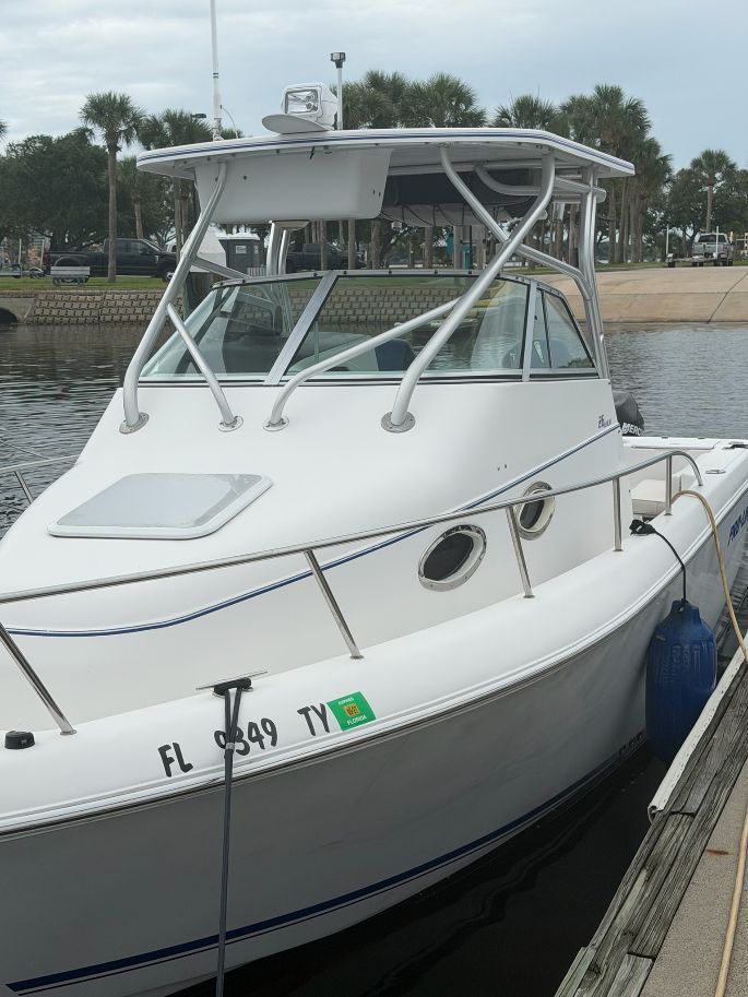 A 2003 Pro-Drive Walkaround boat is docked, featuring a white hull and cabin.