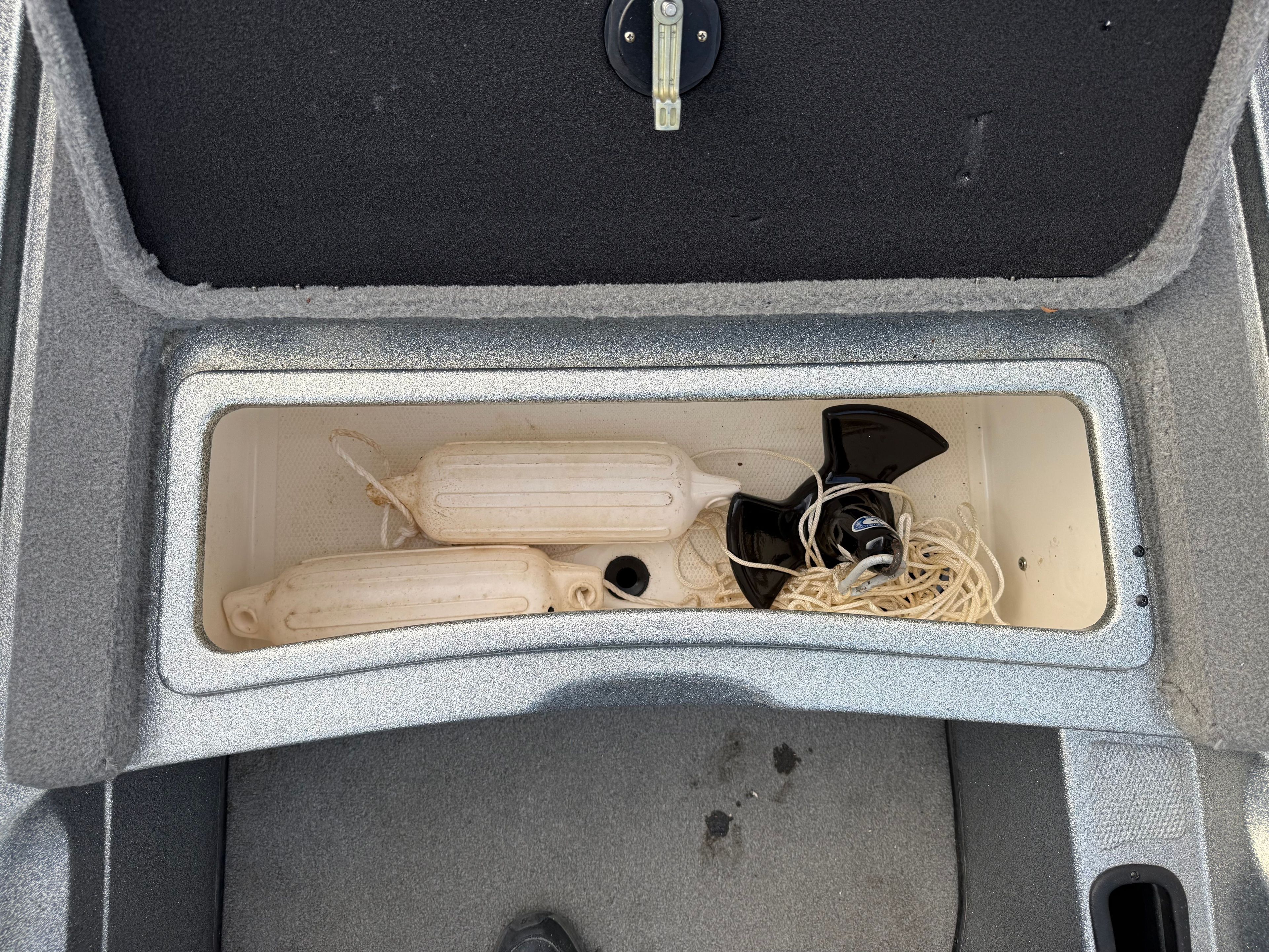 Storage compartment in Nitro NX 898 DC boat with fenders and rope.